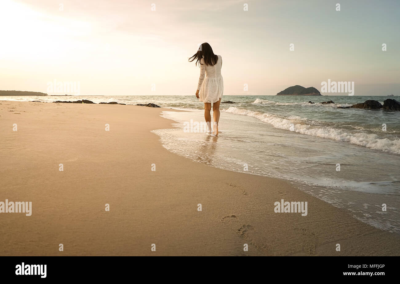 A woman walks along the beach of Thailand. Stock Photo