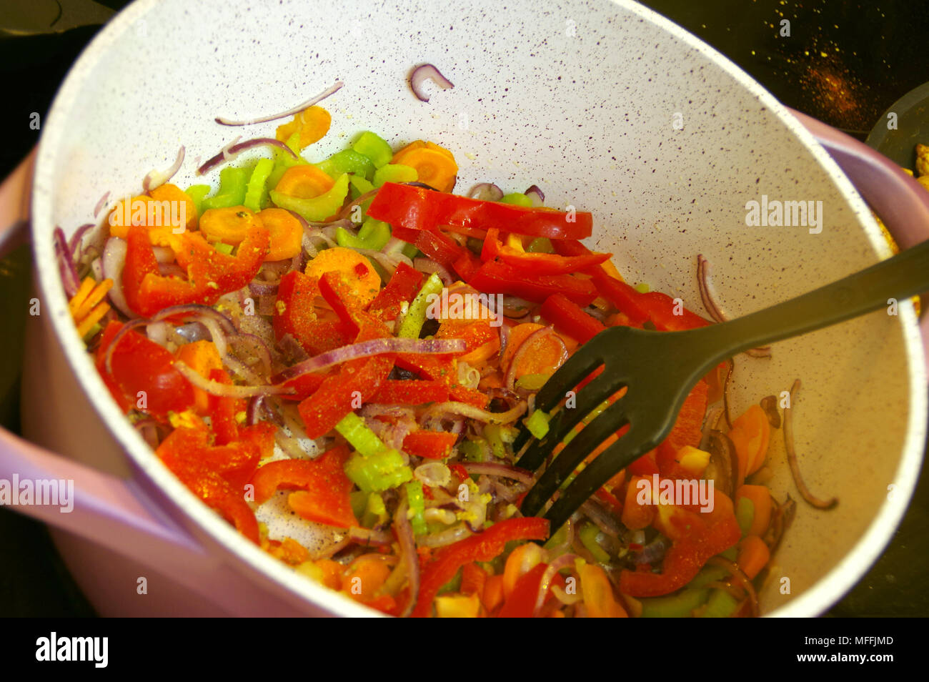 Fresh vegetables in a pot. Fried carrot, onion, celery and red pepper