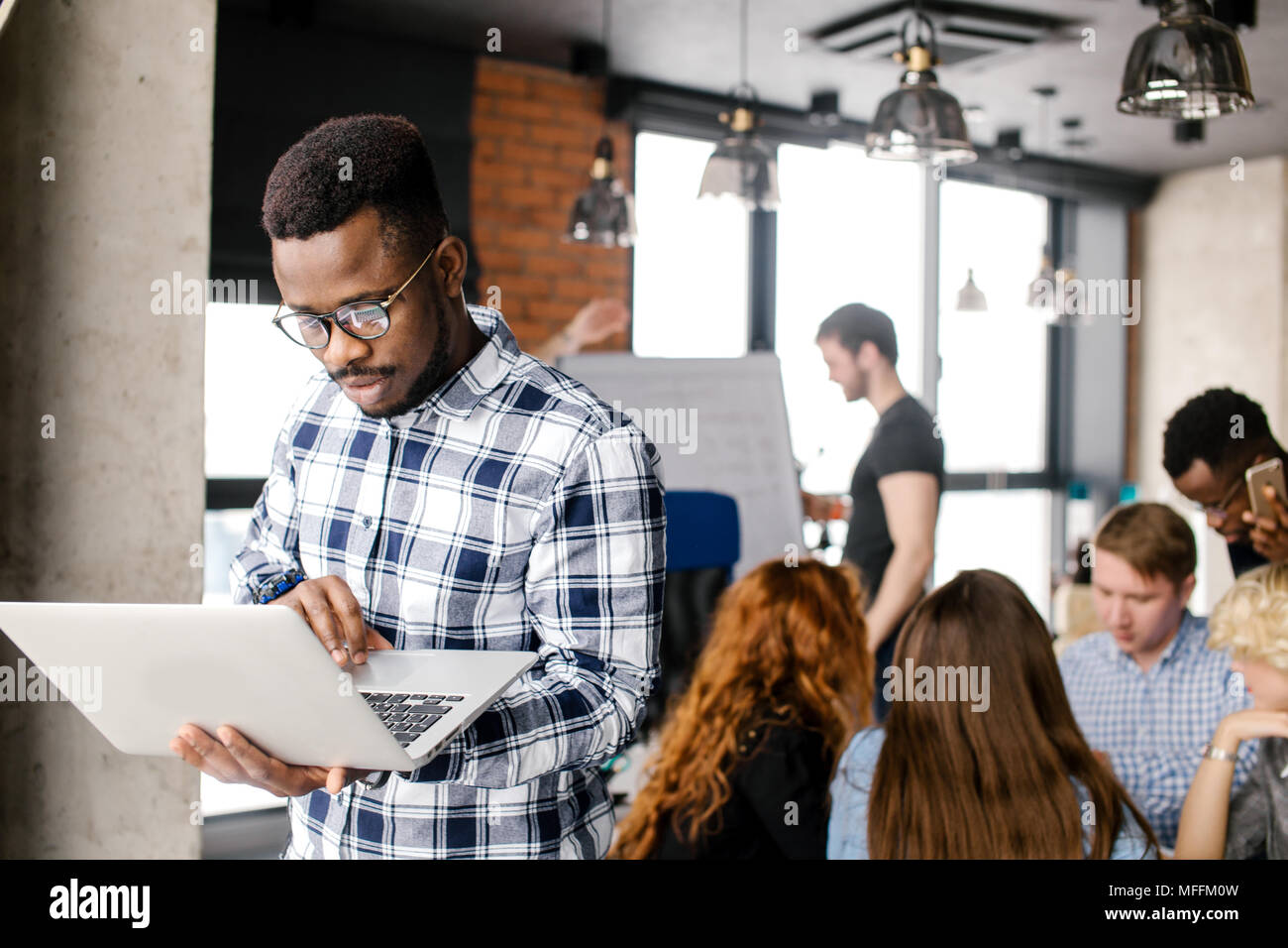 Afro programmer in casual outfit is fixing broken laptop at workplace Stock  Photo - Alamy