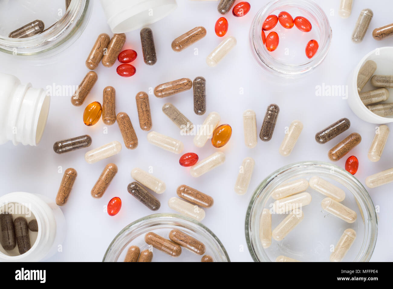 Different medicinal capsule, pills and jars on a light surface Stock Photo