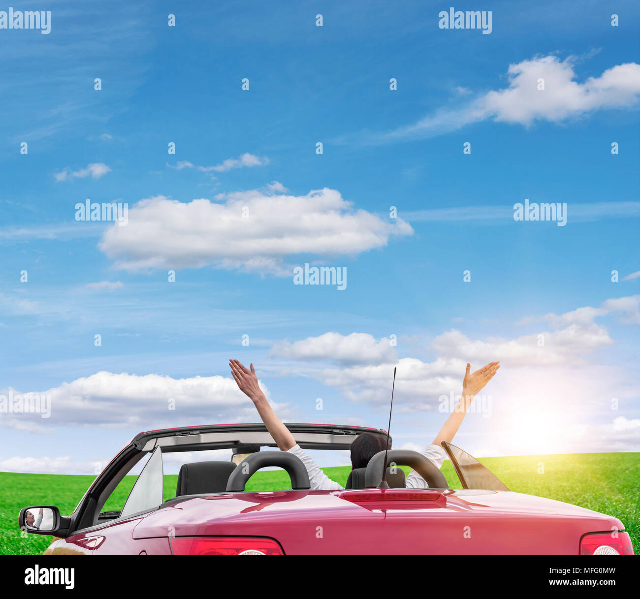 Young woman in a car with a convertible on the road to the nature on a ...
