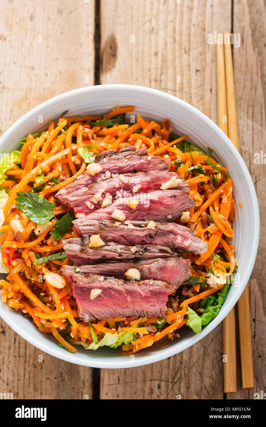 Bangkok beef. Beef with red rice, grated carrot, baby gem lettuce