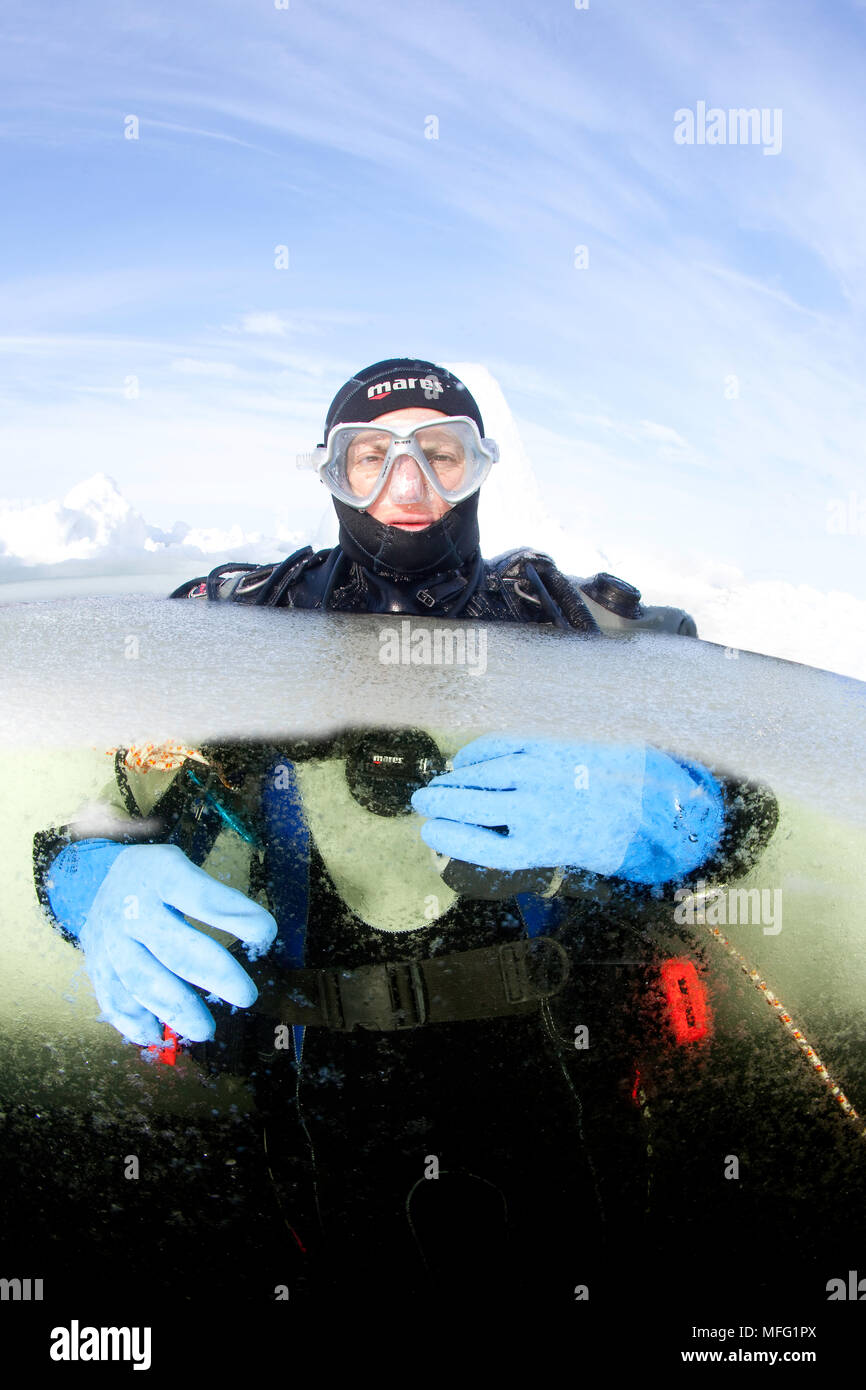 Scuba diver surfacing to the hole, Arctic circle Dive Center, White Sea, Karelia, northern Russia Stock Photo