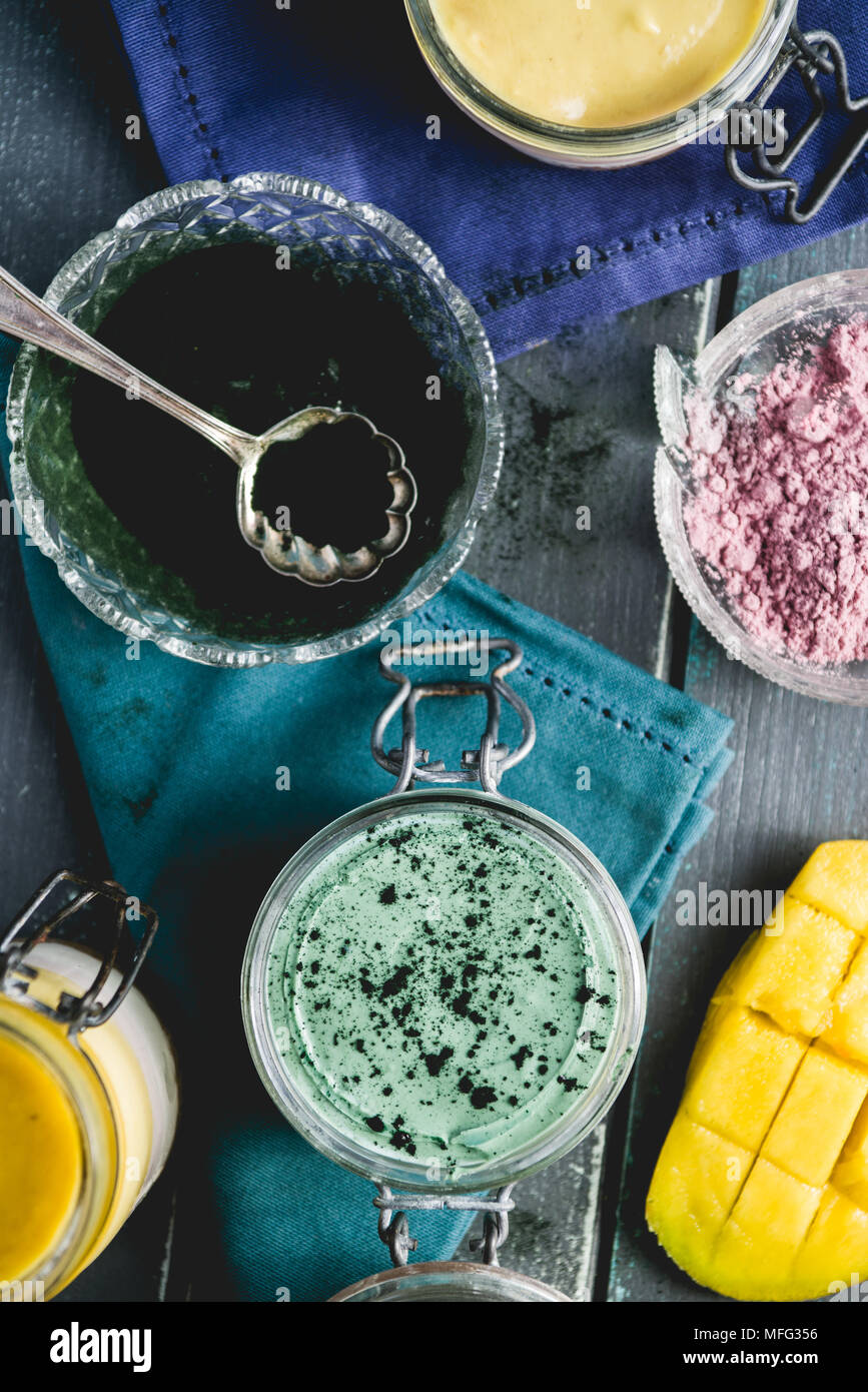 Cheesecake on a glass jar, made with mango and spirulina powder, with chia  seeds and coconut powder, over a wooden blue background Stock Photo - Alamy