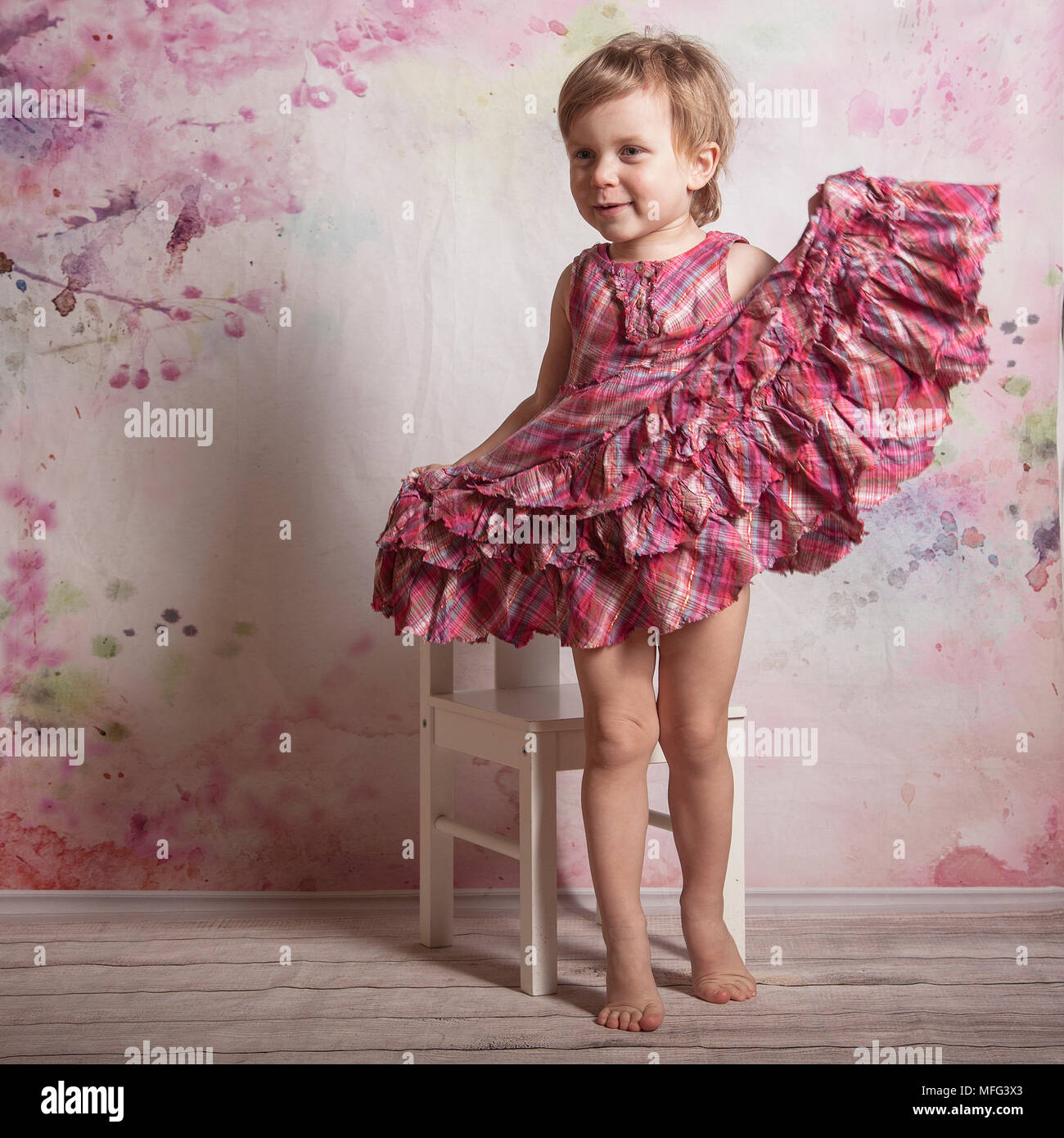 Studio shot of a happy little girl in pink dress Stock Photo - Alamy