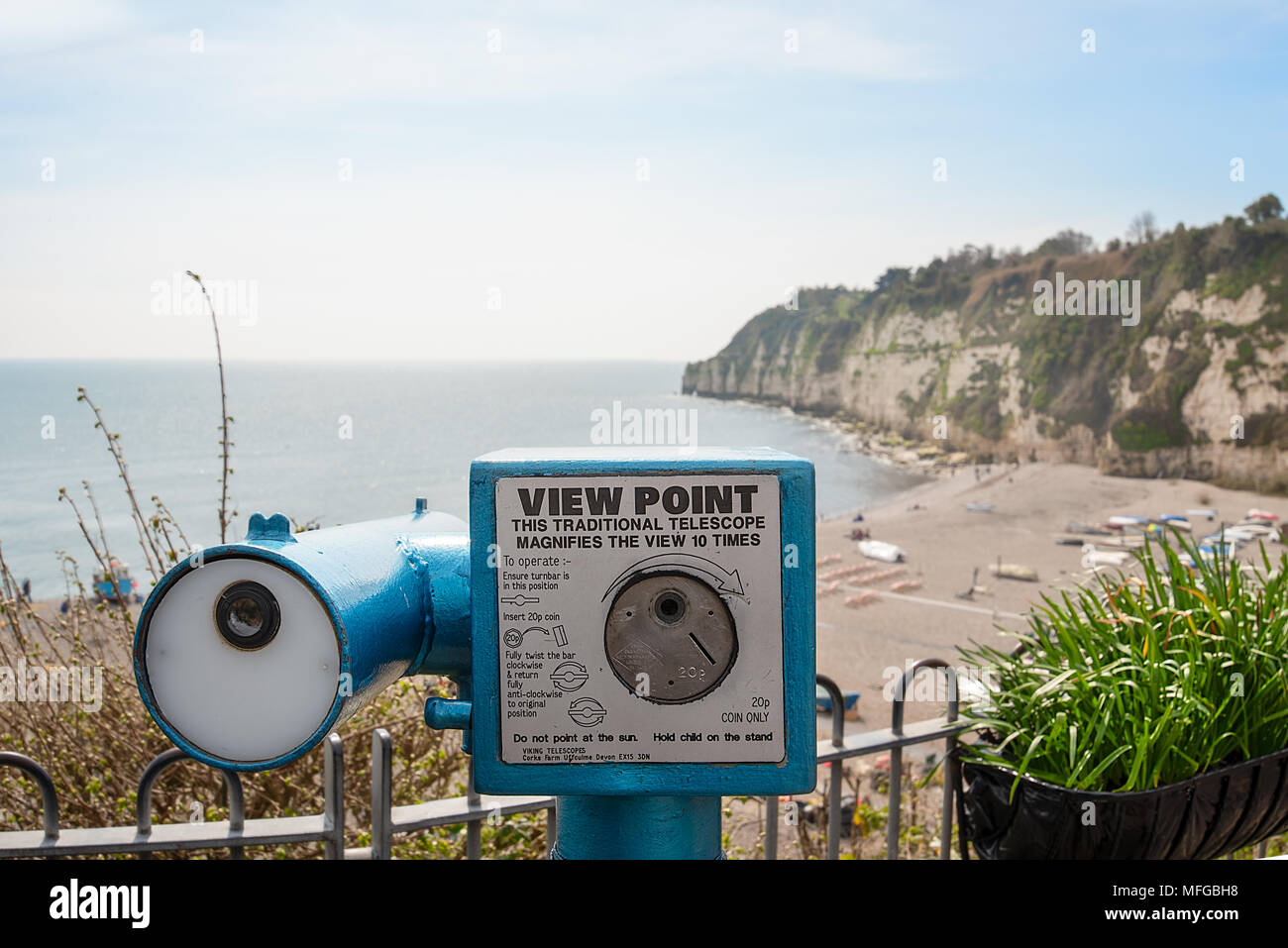 A traditional coin operated View Point telescope over looking the seafront and chalk cliffs of the village of Beer, Devon, England. Stock Photo