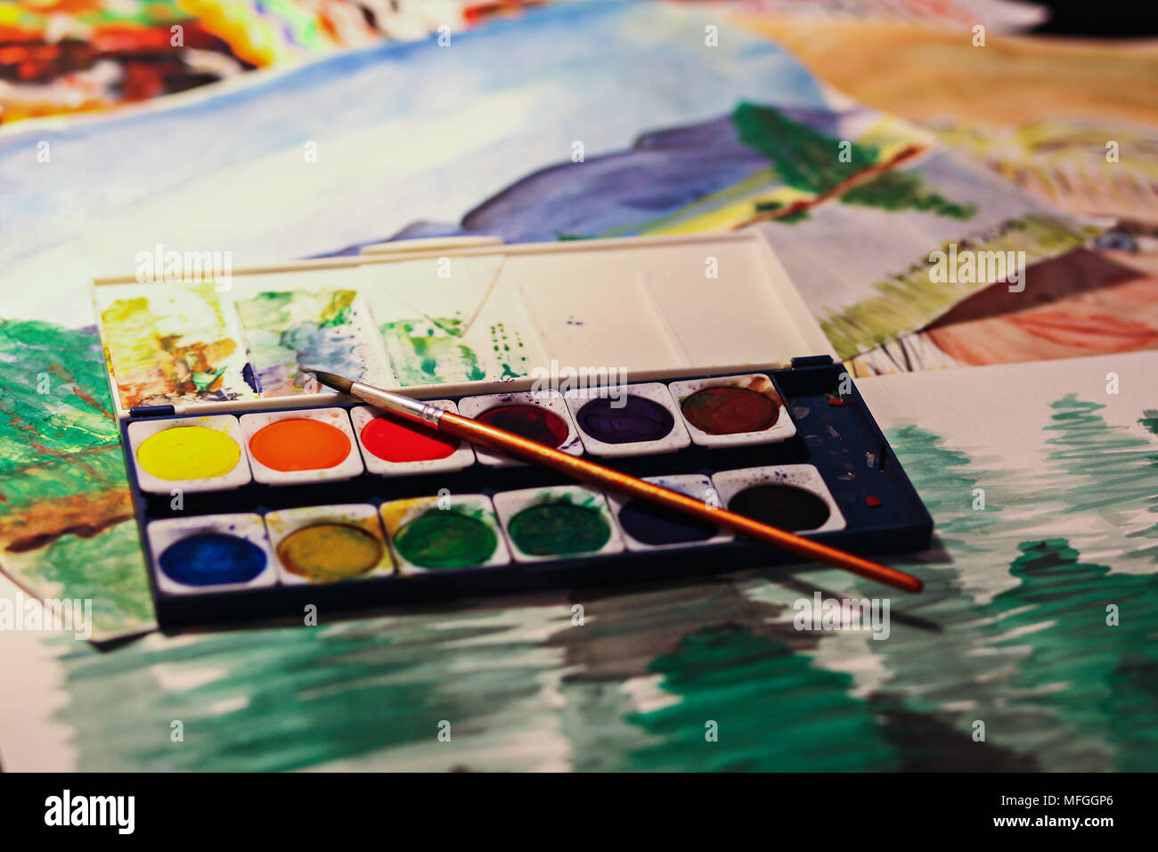 Water colour, a brush and paper. Shallow depth of field. Stock Photo