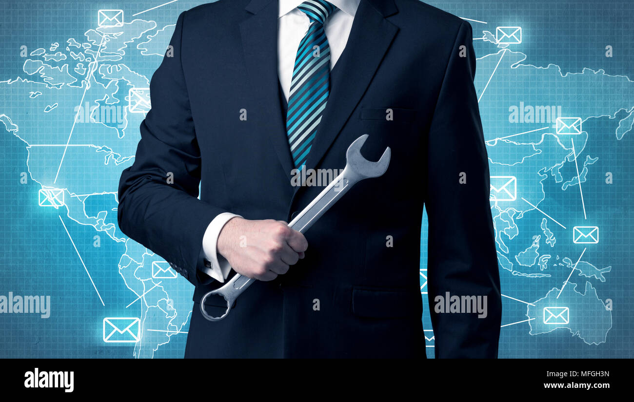 Businessman holding tool with global map graphic on the background Stock Photo