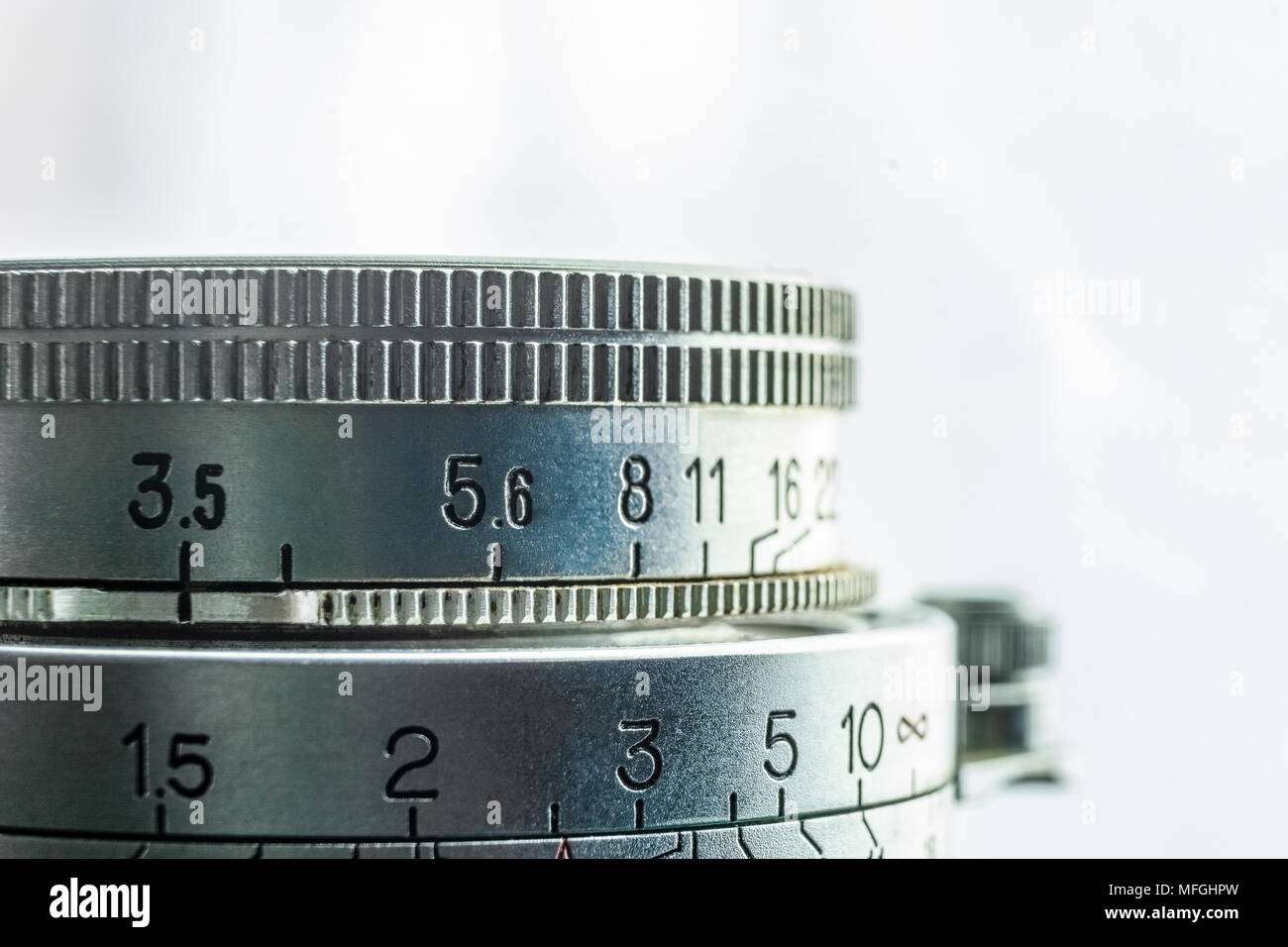 High key closeup of an old vintage camera lens with the engraved values