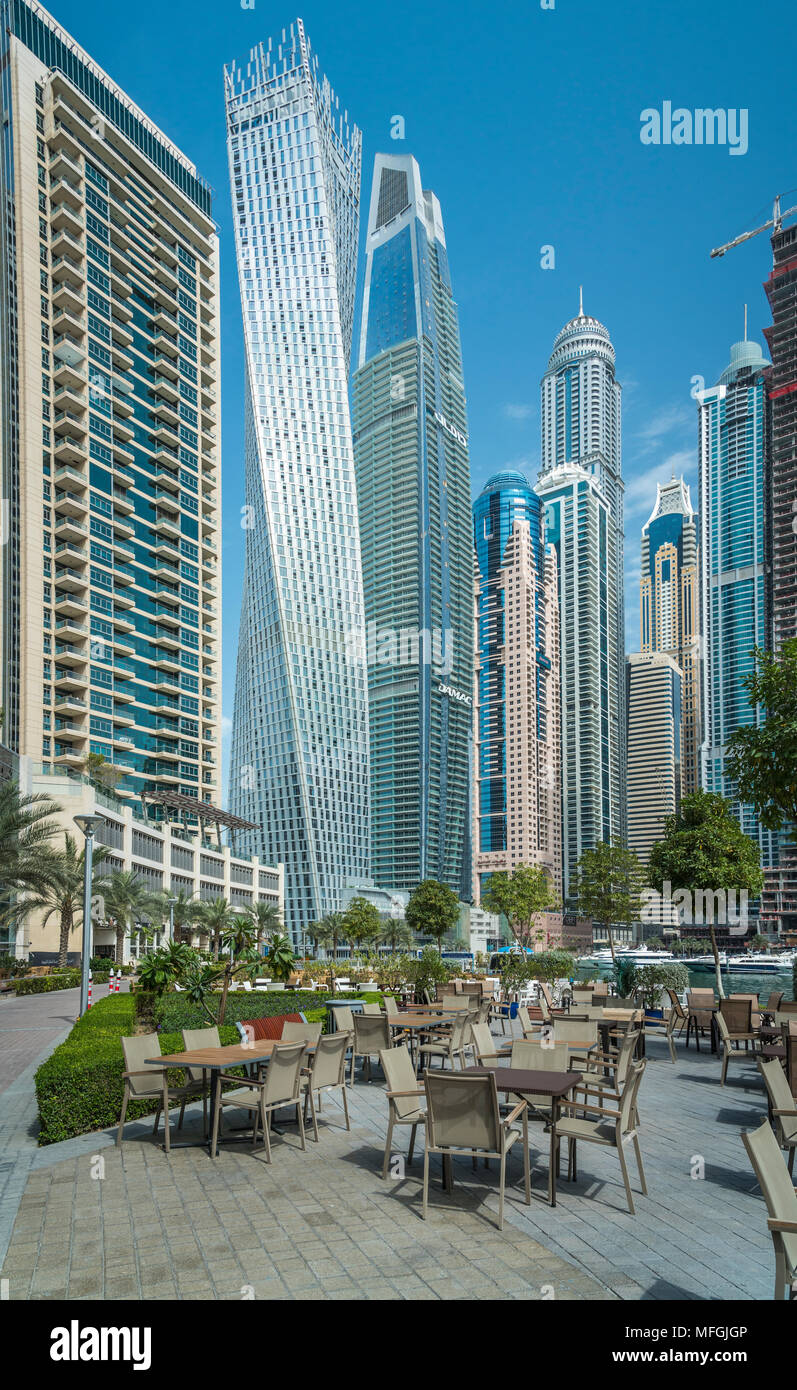 An outdoor restaurant and tall buildings of the Dubai marina, UAE