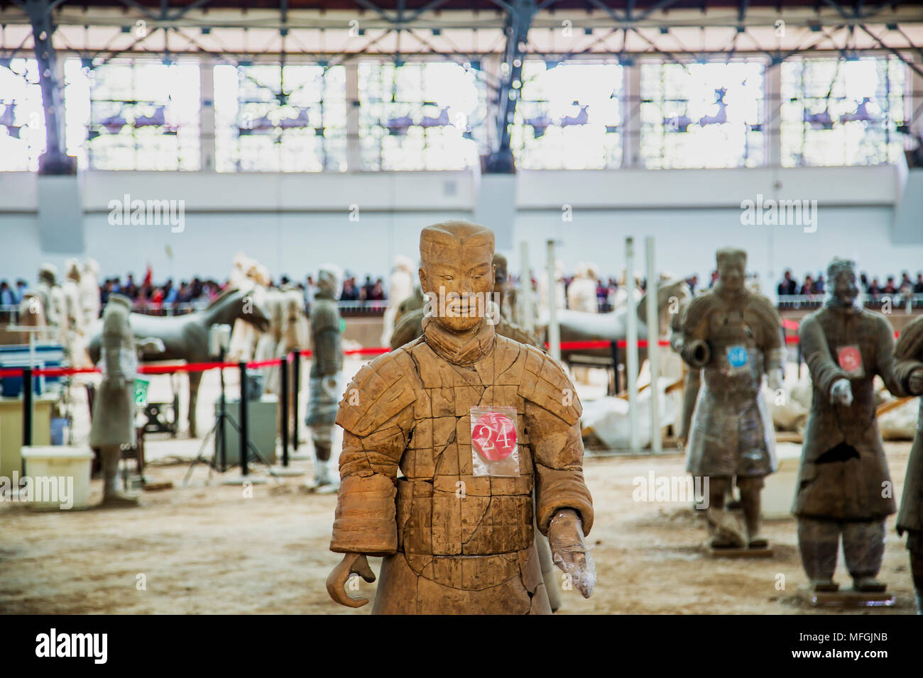 Terracotta Warriors - Terracotta army soldier stands in the restoration area wrapped in plastic and numbered. Breaks can be seen where pieced together Stock Photo