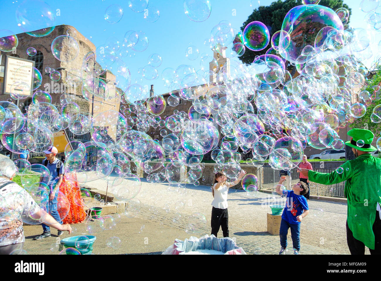 Street performance, A busker blowing giant soap bubbles with loops , rome, italy Stock Photo