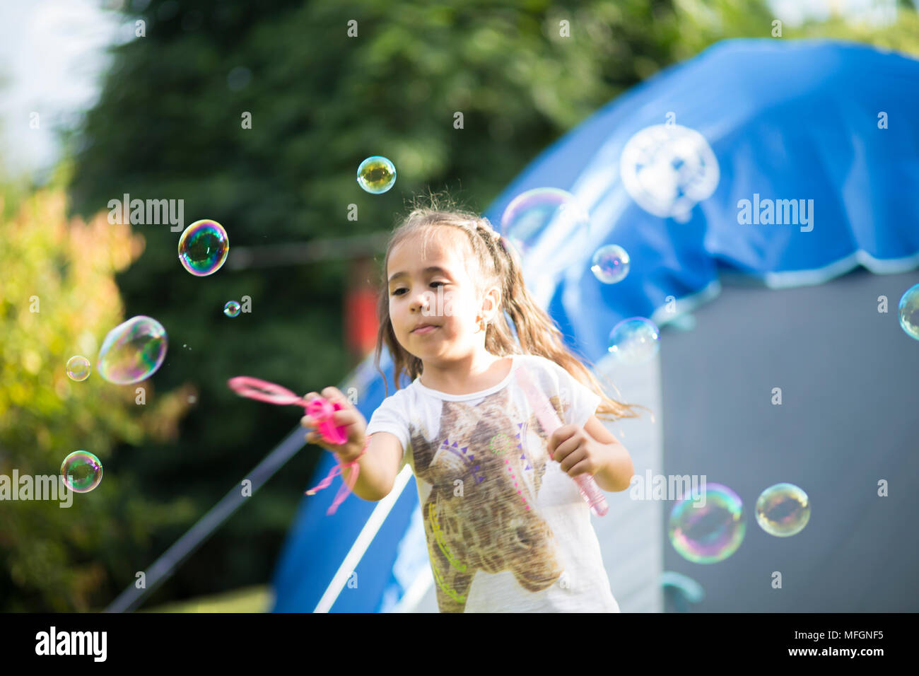 Happy Girl Playing with Soap Bubbles Stock Photo - Alamy