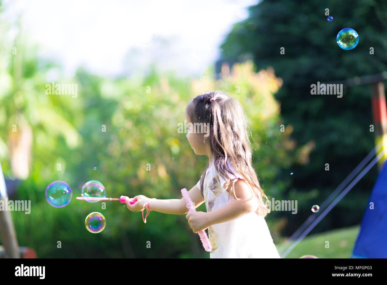 Happy Girl Playing with Soap Bubbles Stock Photo - Alamy