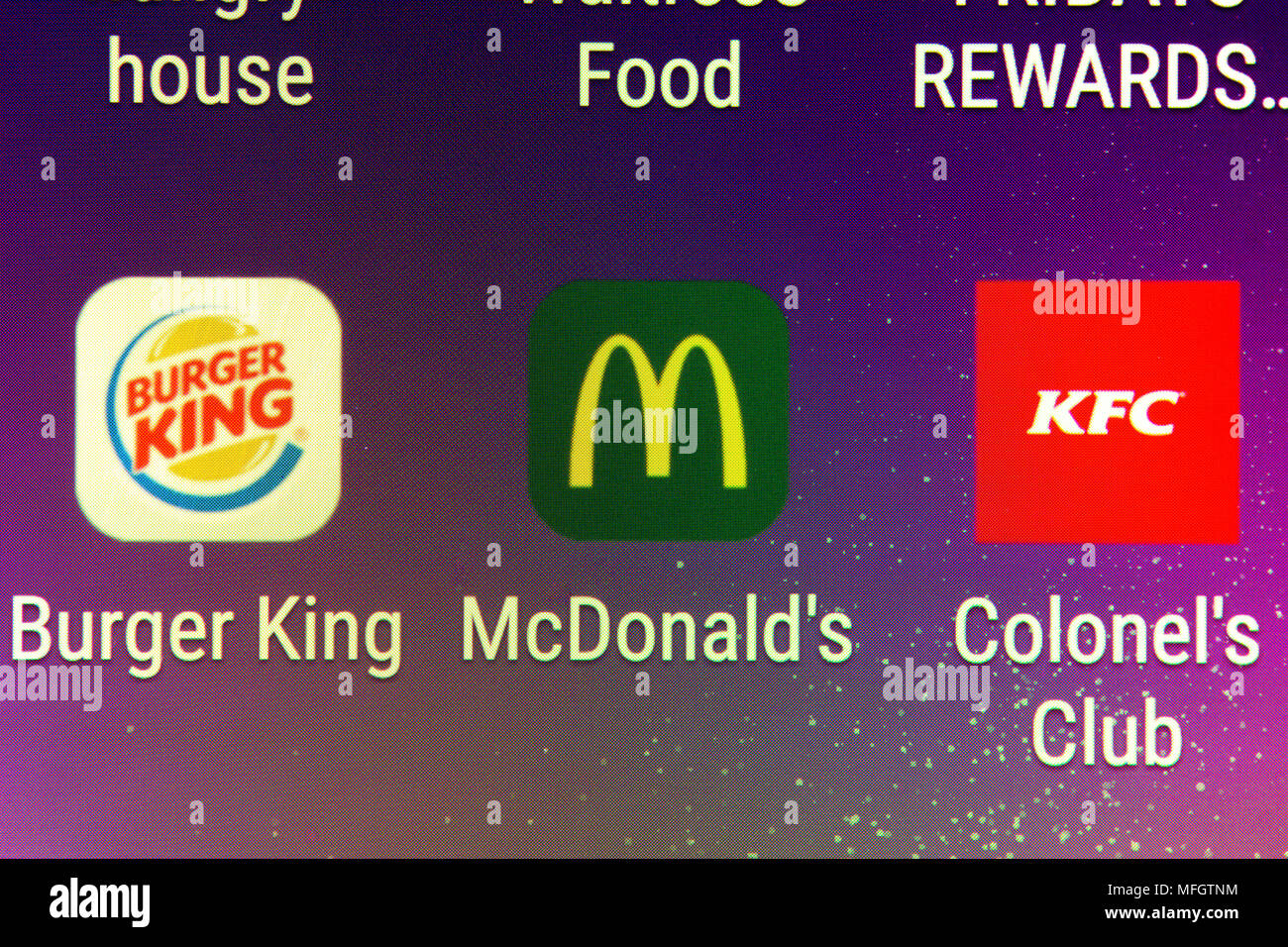 A closeup on the Burger King, McDonald's and KFC mobile phone apps Stock Photo