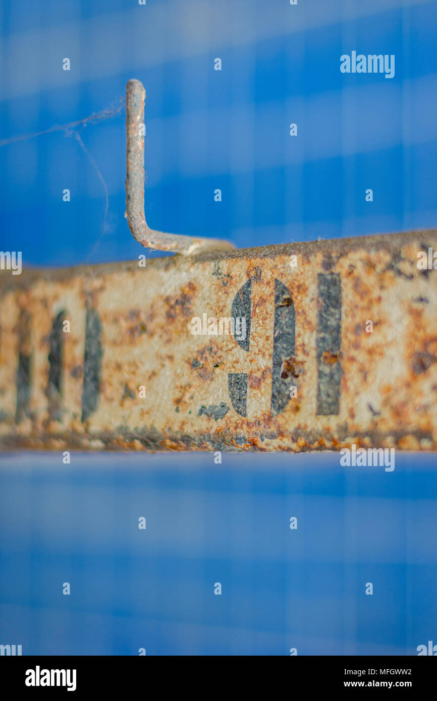 Rusted numbers on the hangers of the abandoned swimming pool changing room Stock Photo