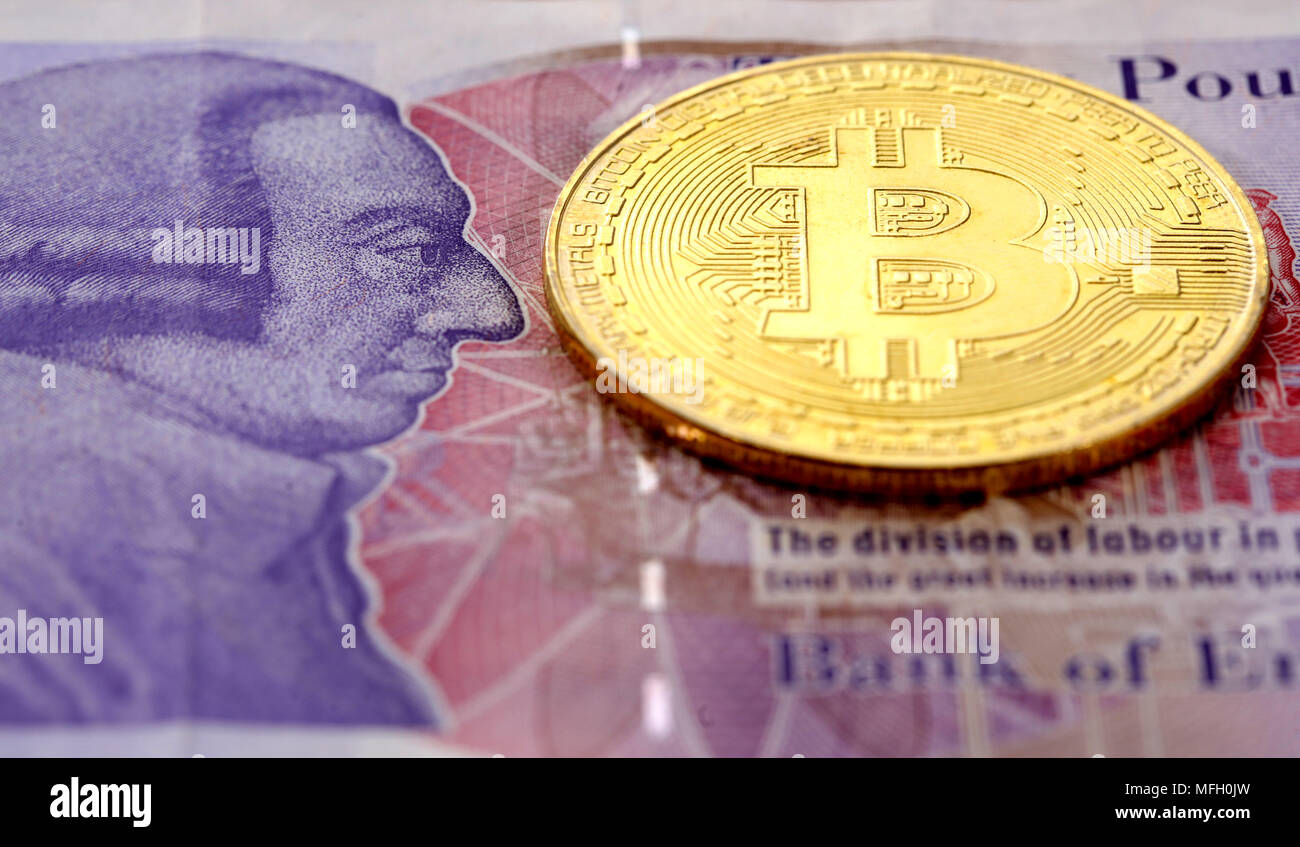 Single virtual cryptocurrency money Bitcoin golden coin on United Kingdom  Pound sterling banknotes with face of Adam Smith Stock Photo - Alamy
