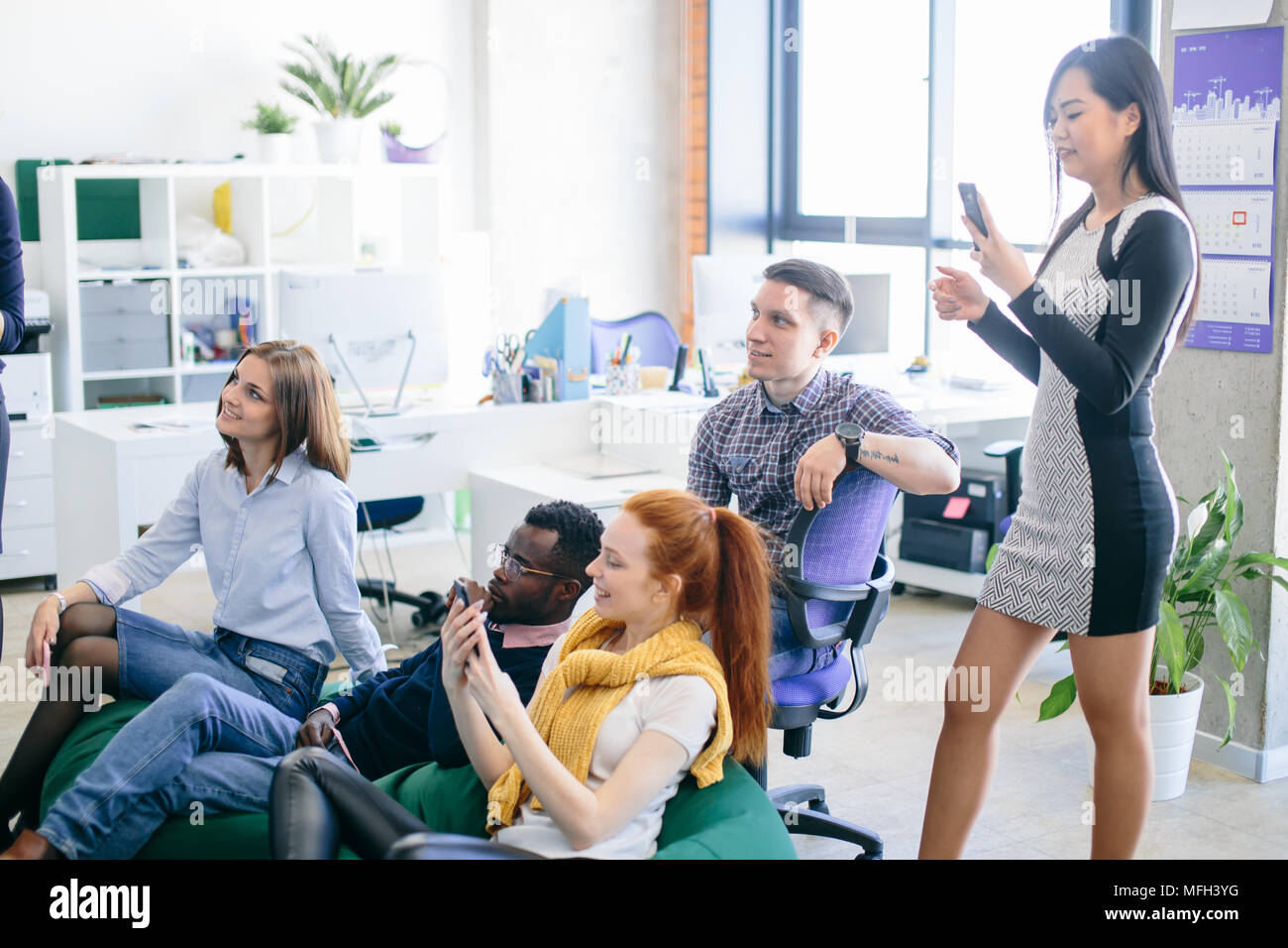 multi ethnic friends are gathered in the training centure with panorama window and loft interior Stock Photo