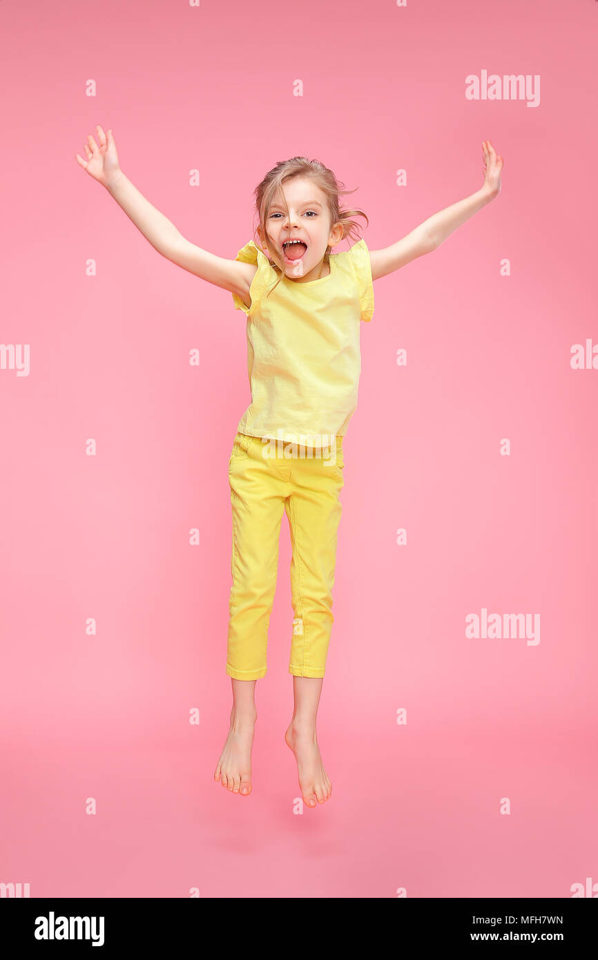Excited girl jumping in studio Stock Photo - Alamy