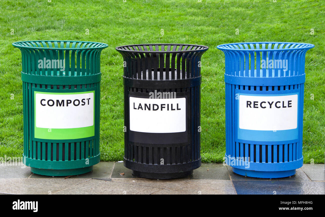 Variety of bright colorful trash cans in a park with grass in