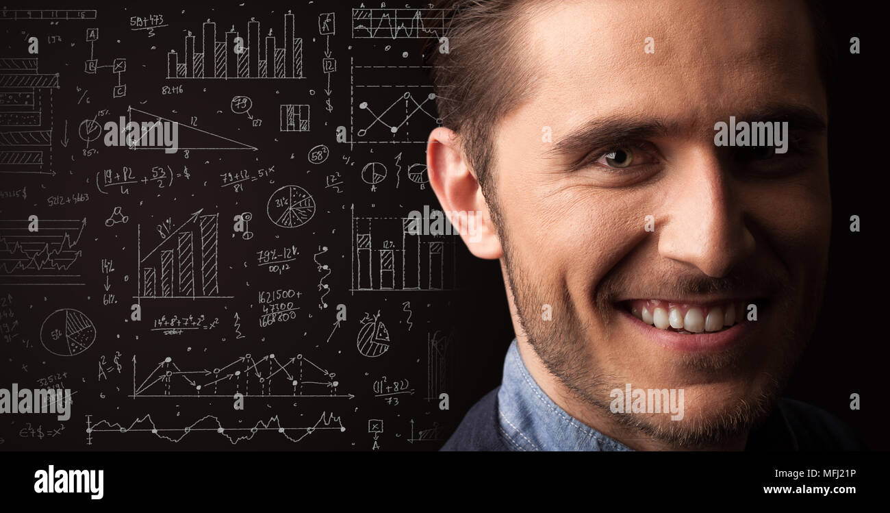 Portrait of a young businessman with charts and graphs scribbled next ...