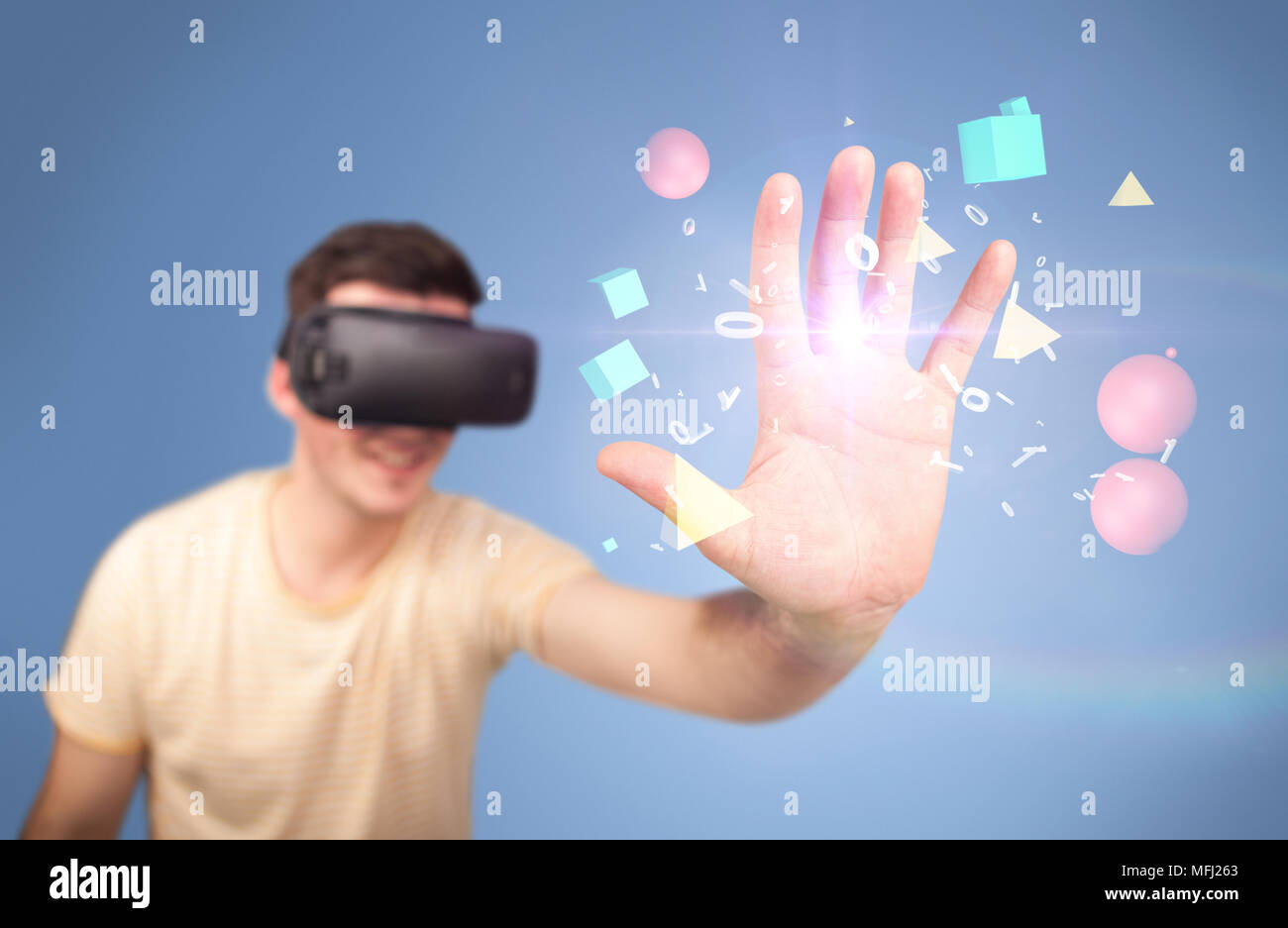 Young impressed man wearing virtual reality goggles with geometric ...