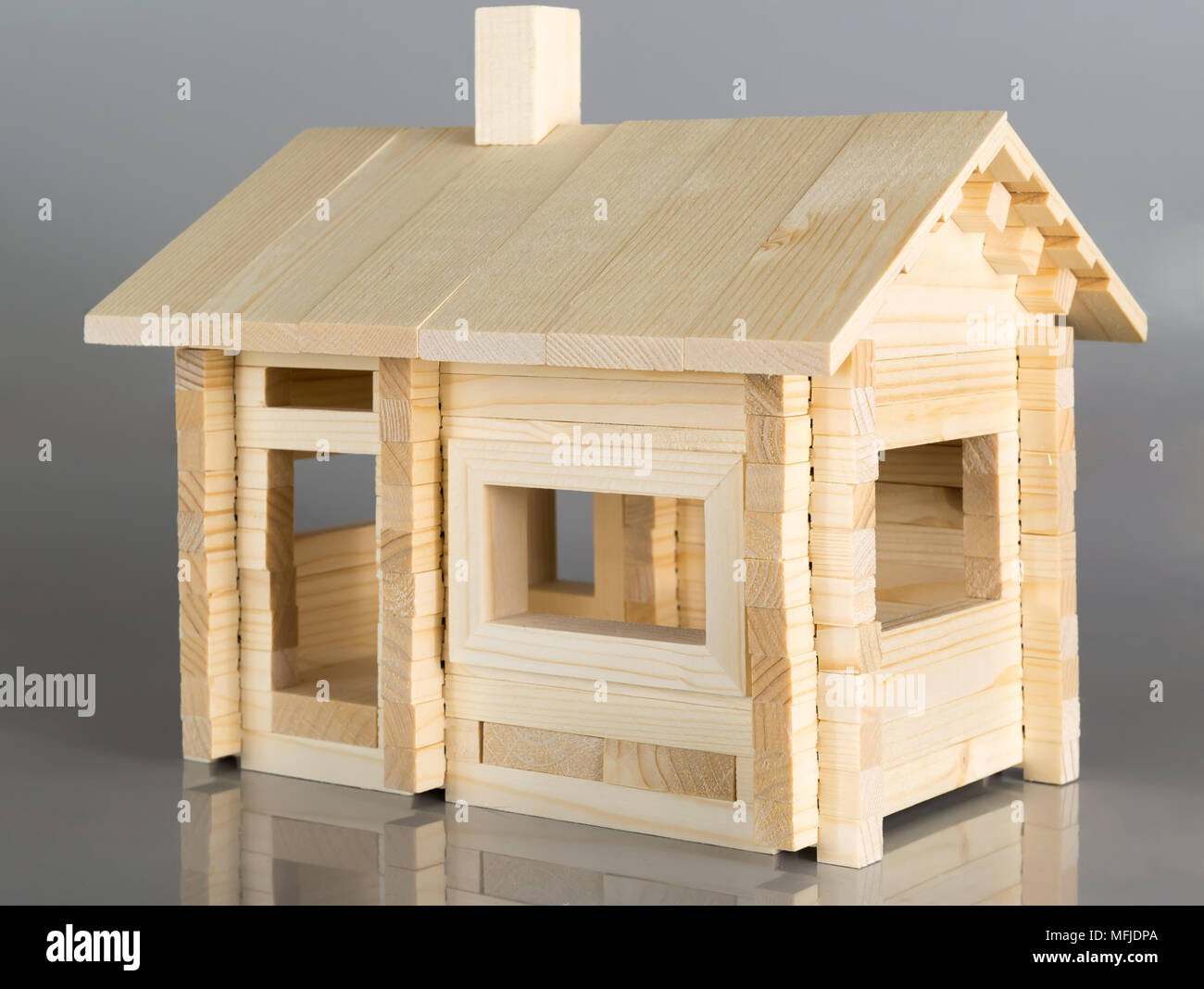 Little weekend house with natural colored toy on gray background Stock Photo