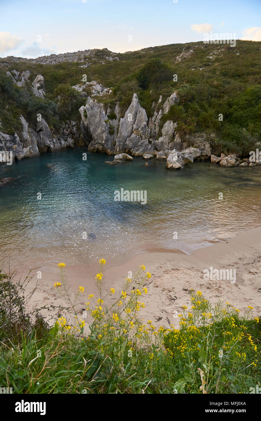 Sunset at Gulpiyuri beach, which is an inland beach arose in flooded sinkhole created by karst erosion (Cantabrian sea, Naves, Llanes, Asturias,Spain) Stock Photo