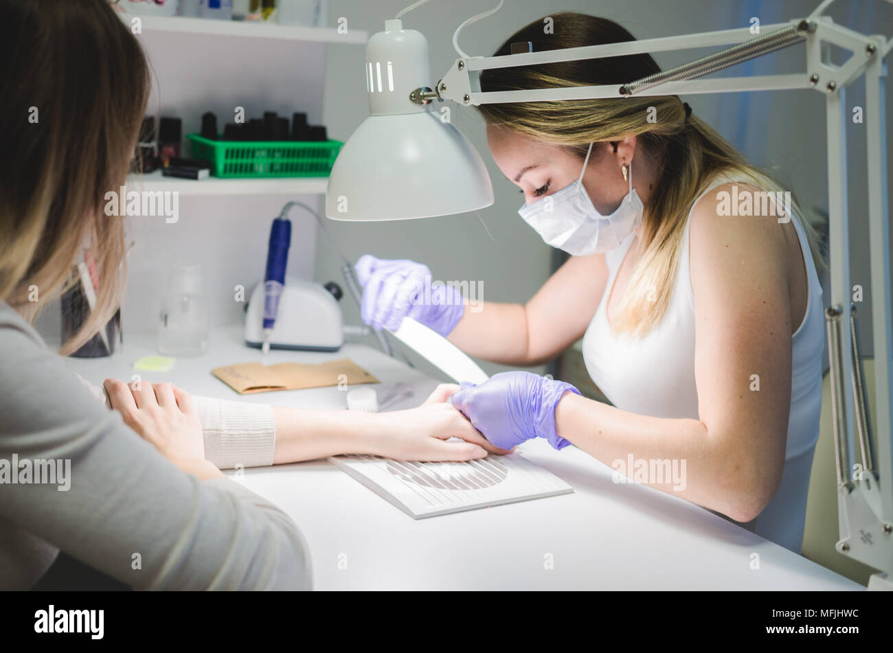 Manicurist master makes manicure. Beauty salon Stock Photo