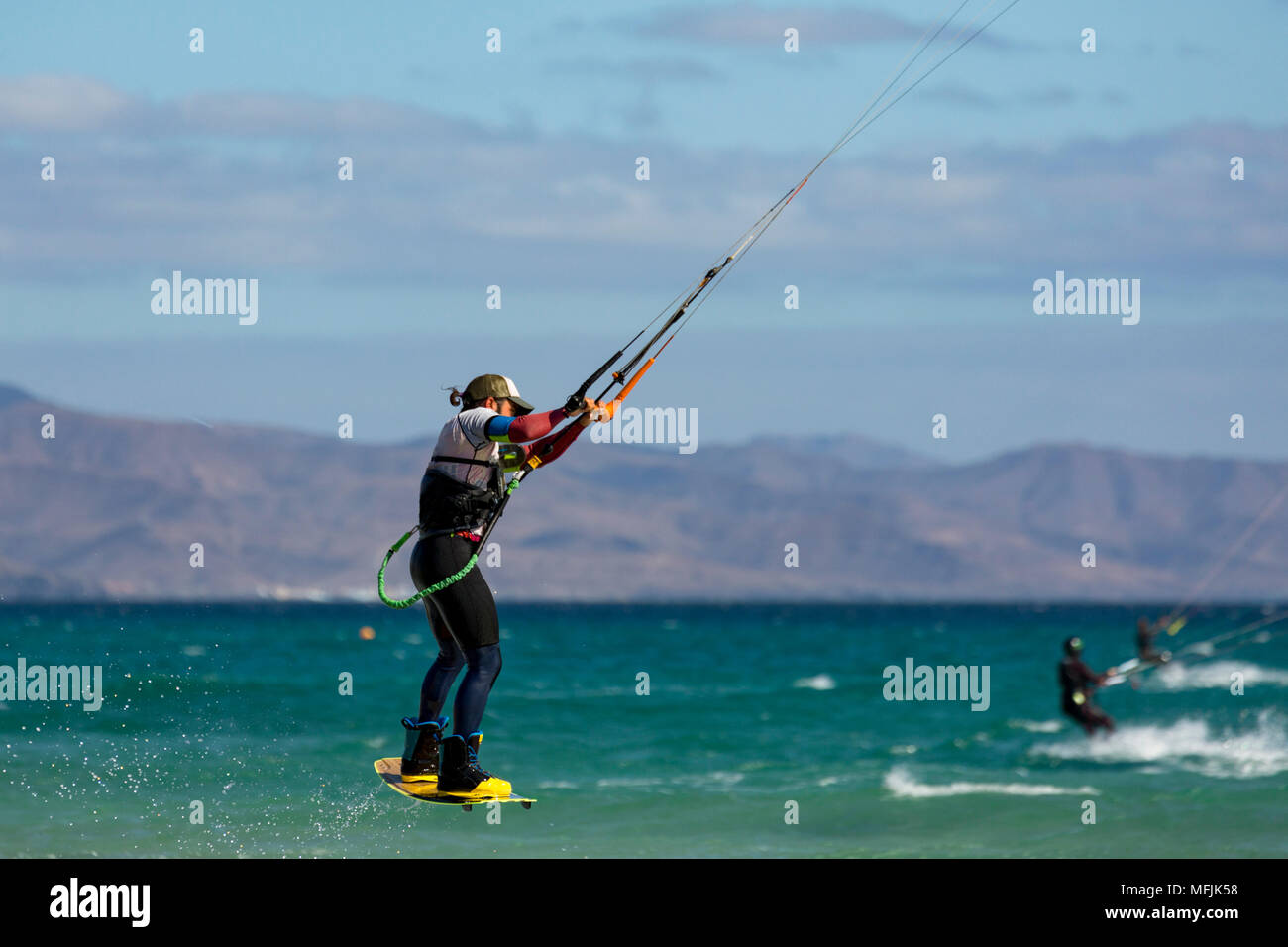 Man jumping whilst kiteboarding off the Playa de La Barca, Costa Calma, on the volcanic island of Fuerteventura, Canary Islands, Spain, Atlantic Stock Photo