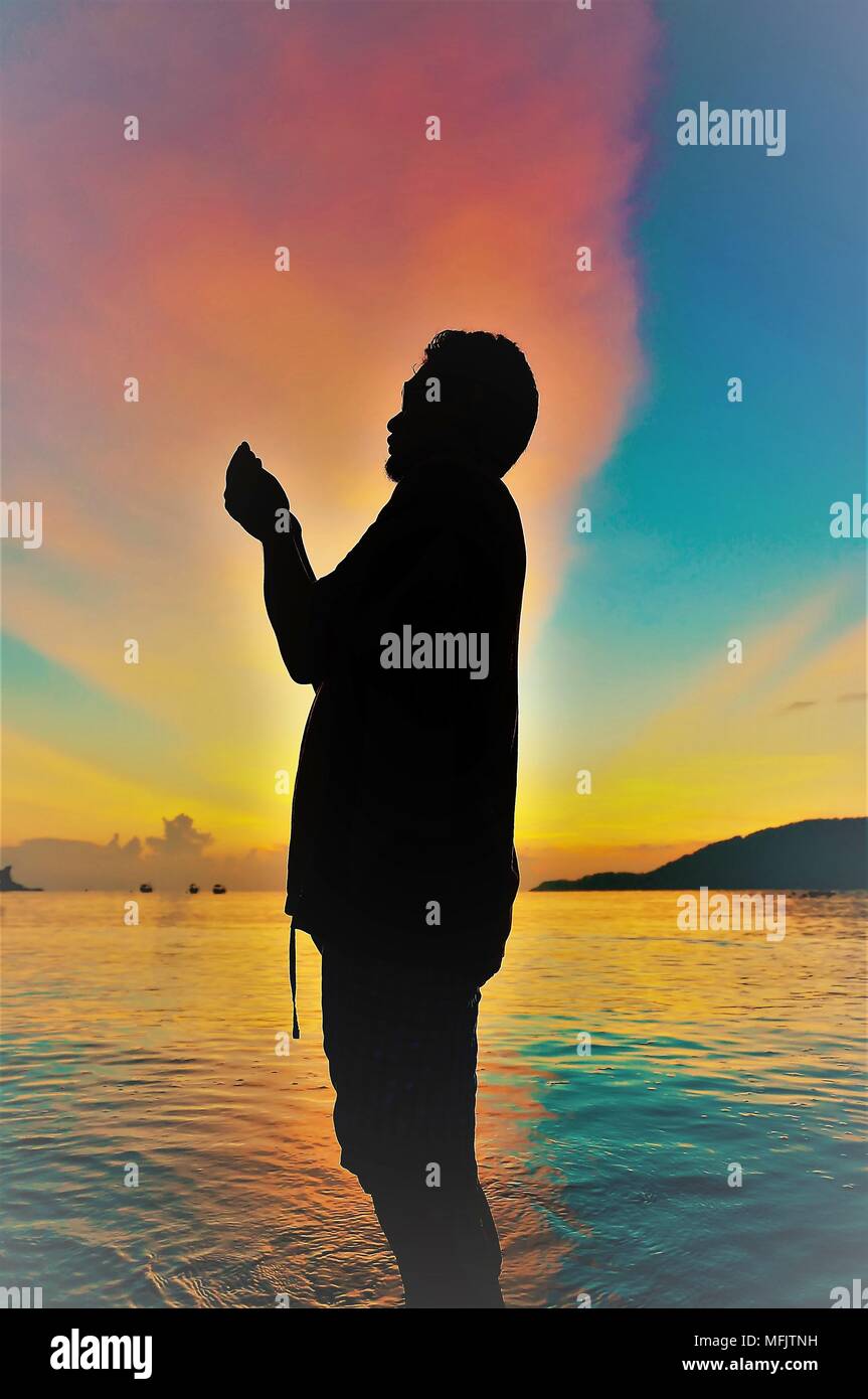 Silhouette of young man on the beach at sunset Stock Photo - Alamy