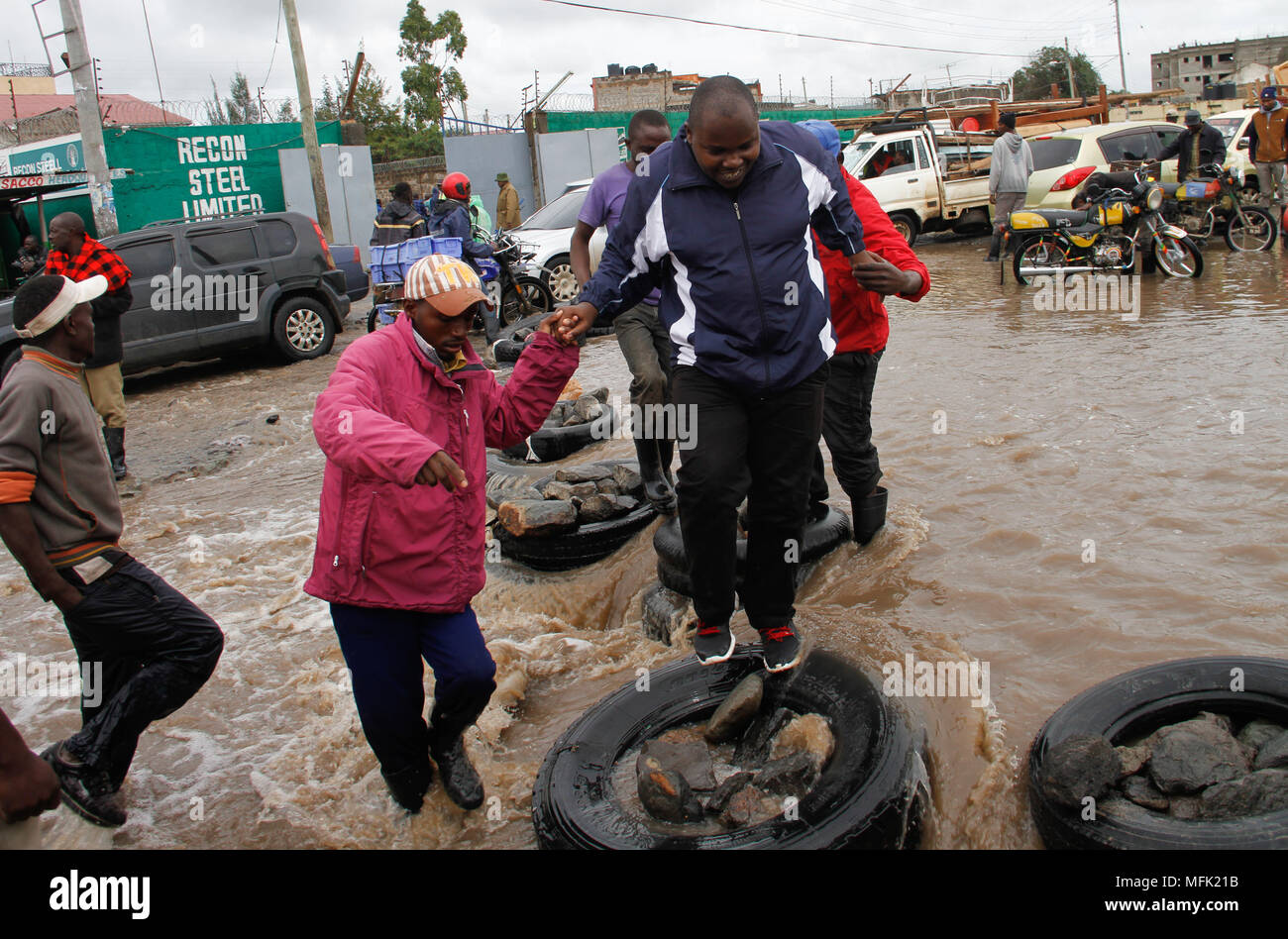 (180426) -- NAIROBI, April, 26, 2018 (Xinhua) -- People use tyres to cross a flooded road in Nairobi, capital of Kenya, April 24, 2018. The Kenya Red Cross Society said on Wednesday that it is providing emergency relief to more than 210,000 people impacted by rising flood waters that continue to wreak havoc in many parts of Kenya. (Xinhua/Fred Mutune)(yk) Credit: Fred Mutune)(yk/Xinhua/Alamy Live News Stock Photo