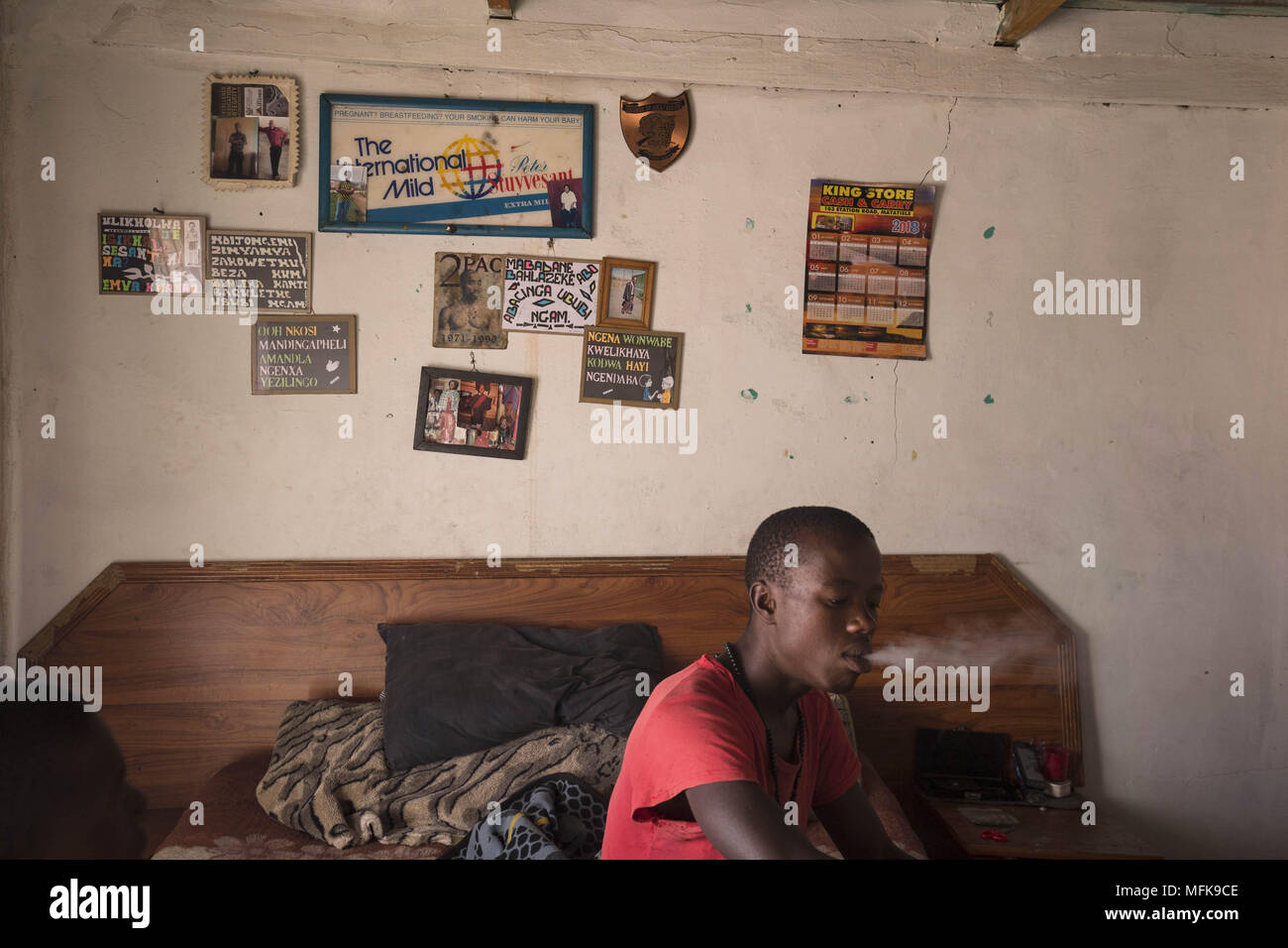 January 12, 2018 - Matatiele, Eastern Cape, South Africa - Jake, 23, sits on his bed and smokes cannabis. He says: 'I have nothing to do all day. I have finished school, but for what? There are no jobs. I am bored, and if I stay at home all day I would become crazy. To keep myself busy I wake up in the morning, then go to town and push people's trollies outside the Spar supermarket. Then I come back home to the village and sell cannabis, and hang out with my friends. I want to find a job and do something meaningful with my life. But there is nothing. You have to be very lucky to find a job aro Stock Photo