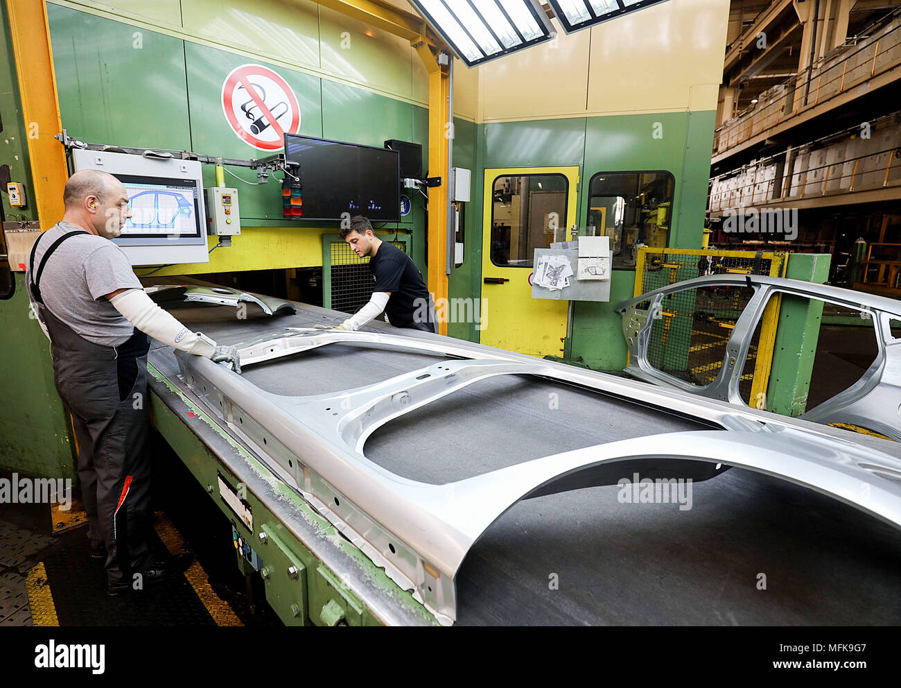 FILED - 24 April 2018, Germany, Cologne: Workers remove parts of a vehicle body from a conveyor belt at the Ford plant in Cologne. Photo: Oliver Berg/dpa Stock Photo