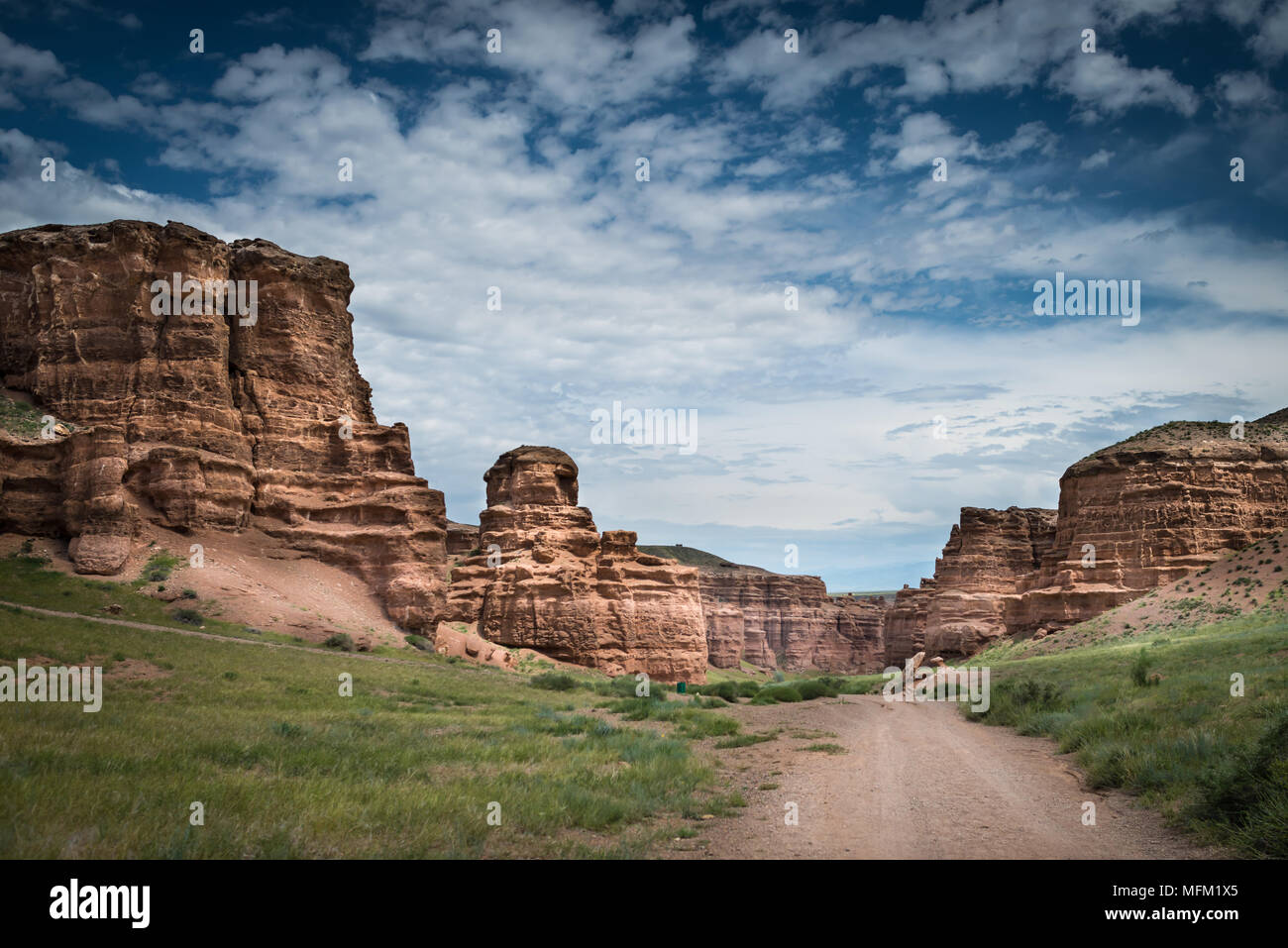 Scenic landscape inside canyon with long country road. Rocks on sides. Cloudy dramatic sky. Stock Photo