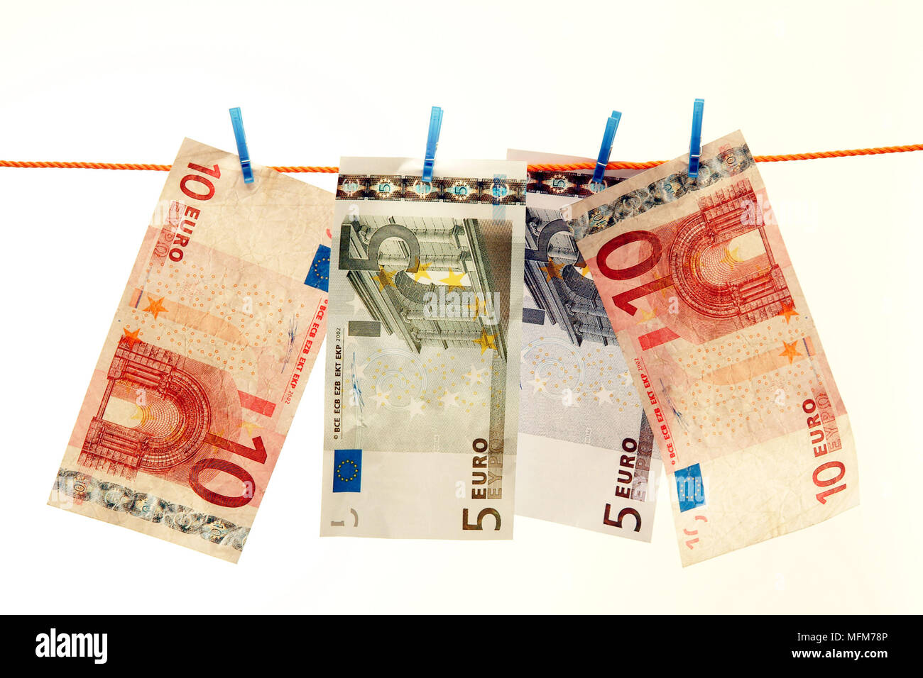 A selection of Euro notes are hanging from a washing line drying. Suggesting criminal activity in laundering funds acquired by illigal means.    Bandp Stock Photo