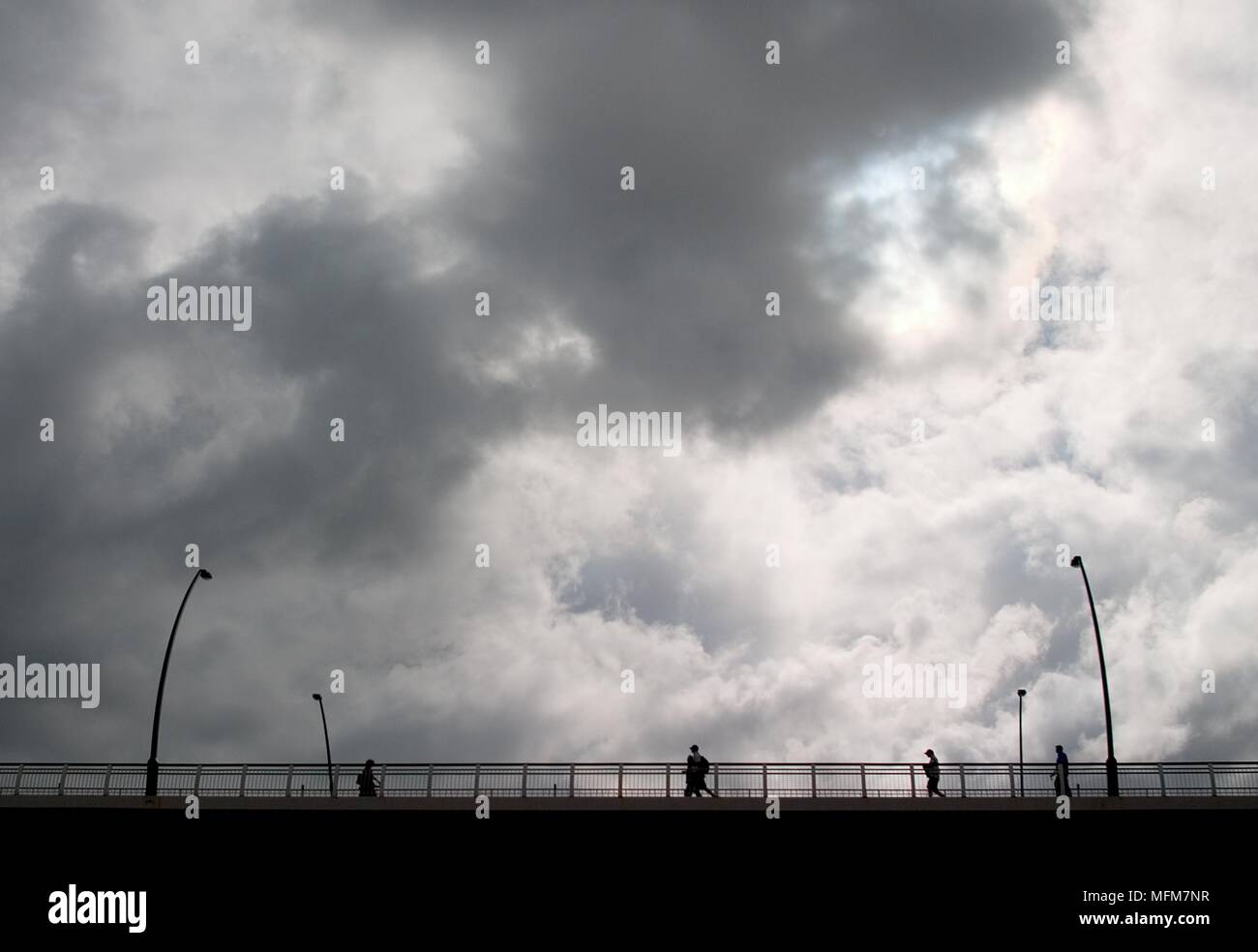Moody Bridge, Brisbane, Queensland, Australia.  Pedestrians wlaking over Victoria Bridge in Brisbane's city centre as moody rain clouds decend.     Da Stock Photo