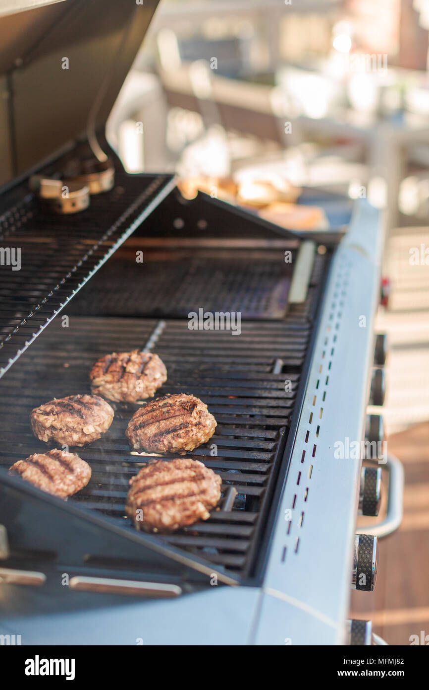 Grilling classic burgers on outdoor gas grill in the Summer Stock Photo Alamy