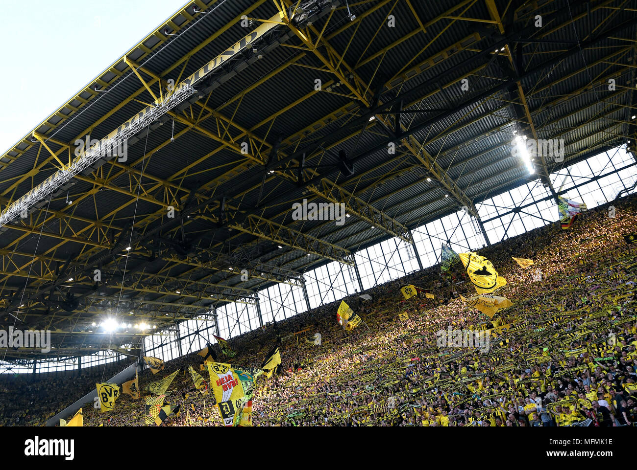 Supporters of Borussia Dortmund with flags on the south terrace of the Signal Iduna Park. Stock Photo