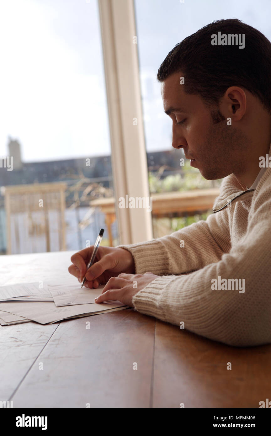 Side profile of a young man writing on an envelope Ref: CRB412 10004 ...