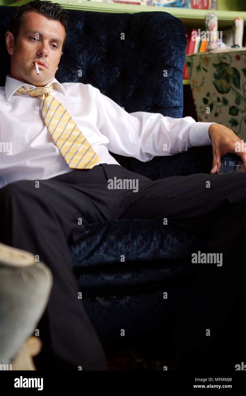 Young man sitting on a couch and holding a glass of wine Ref: CRB413 ...