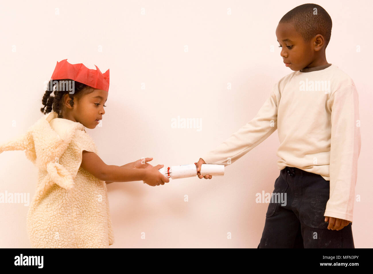 Side profile of a boy and a girl pulling a christmas cracker   Ref:   Compulsory Credit: Stock Photo