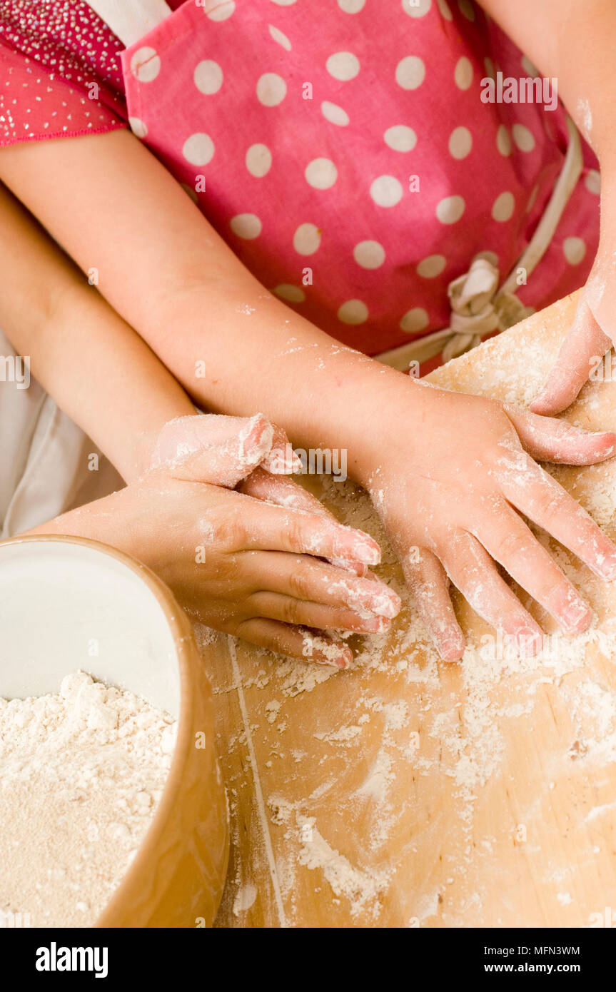 Closeup of two children kneading dough Ref Compulsory Credit Stock