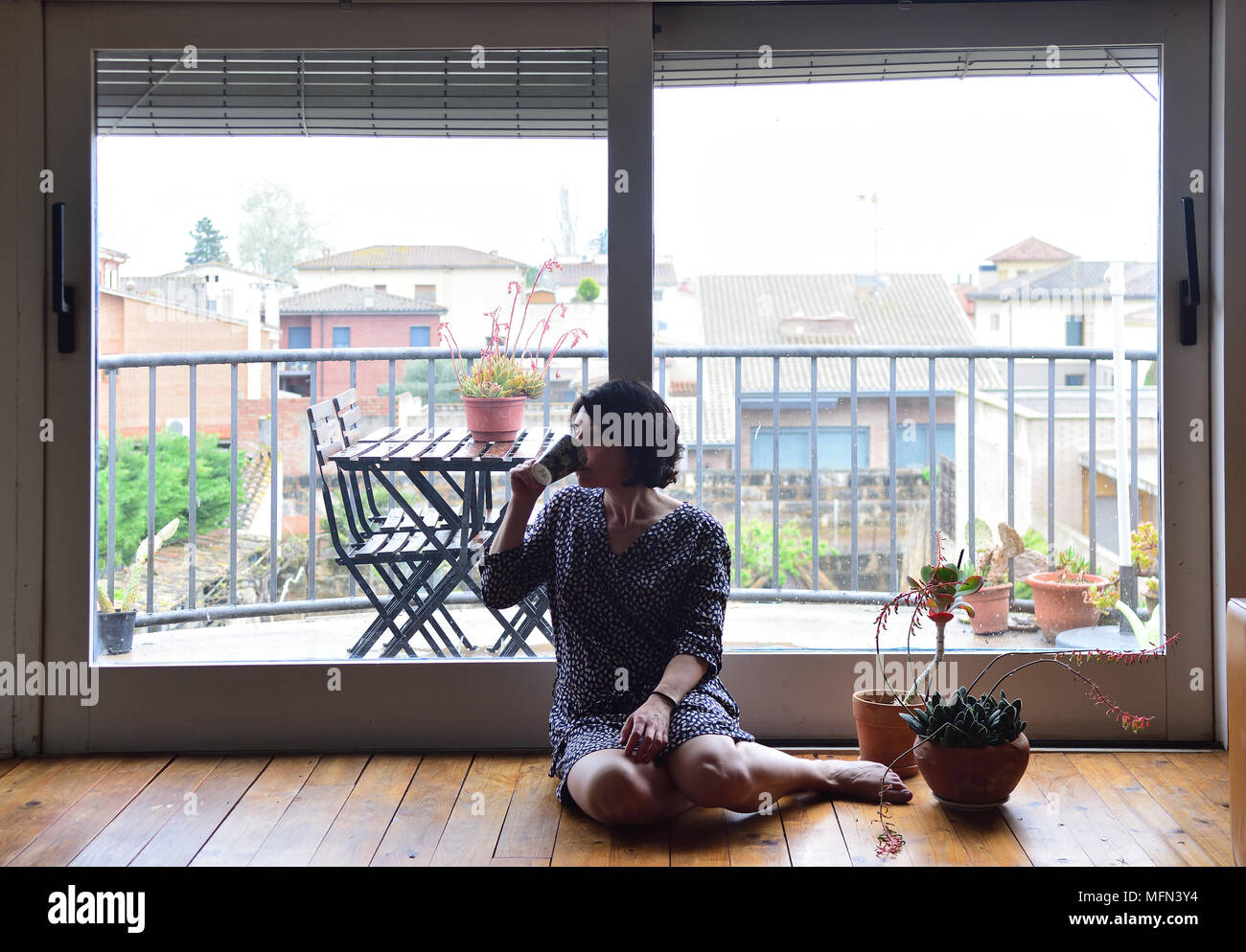 sad woman sitting and looking out the window Stock Photo - Alamy