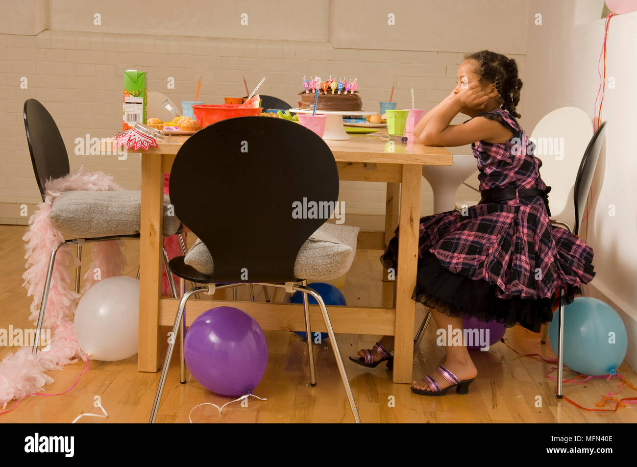 Side profile of a girl sitting on a chair at a birthday party and thinking Ref Compulsory Credit Stock Photo Alamy