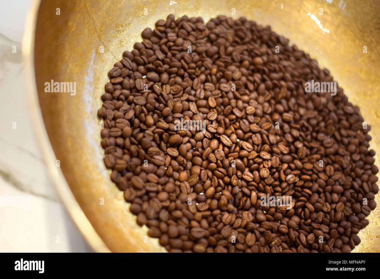 Coffee beans in brass bowl Stock Photo - Alamy