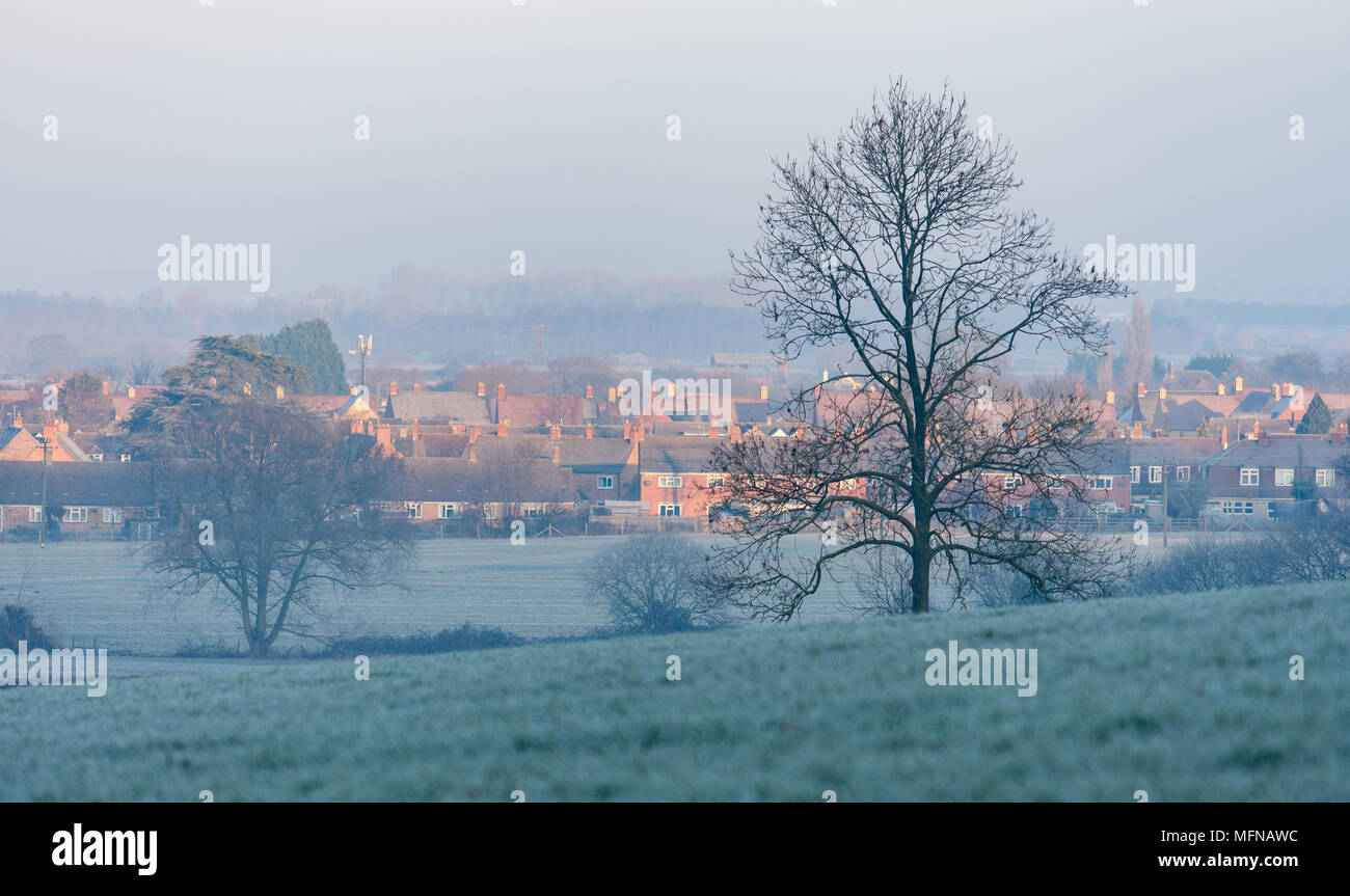 Winter morning mist hangs over a Cotswold village Stock Photo