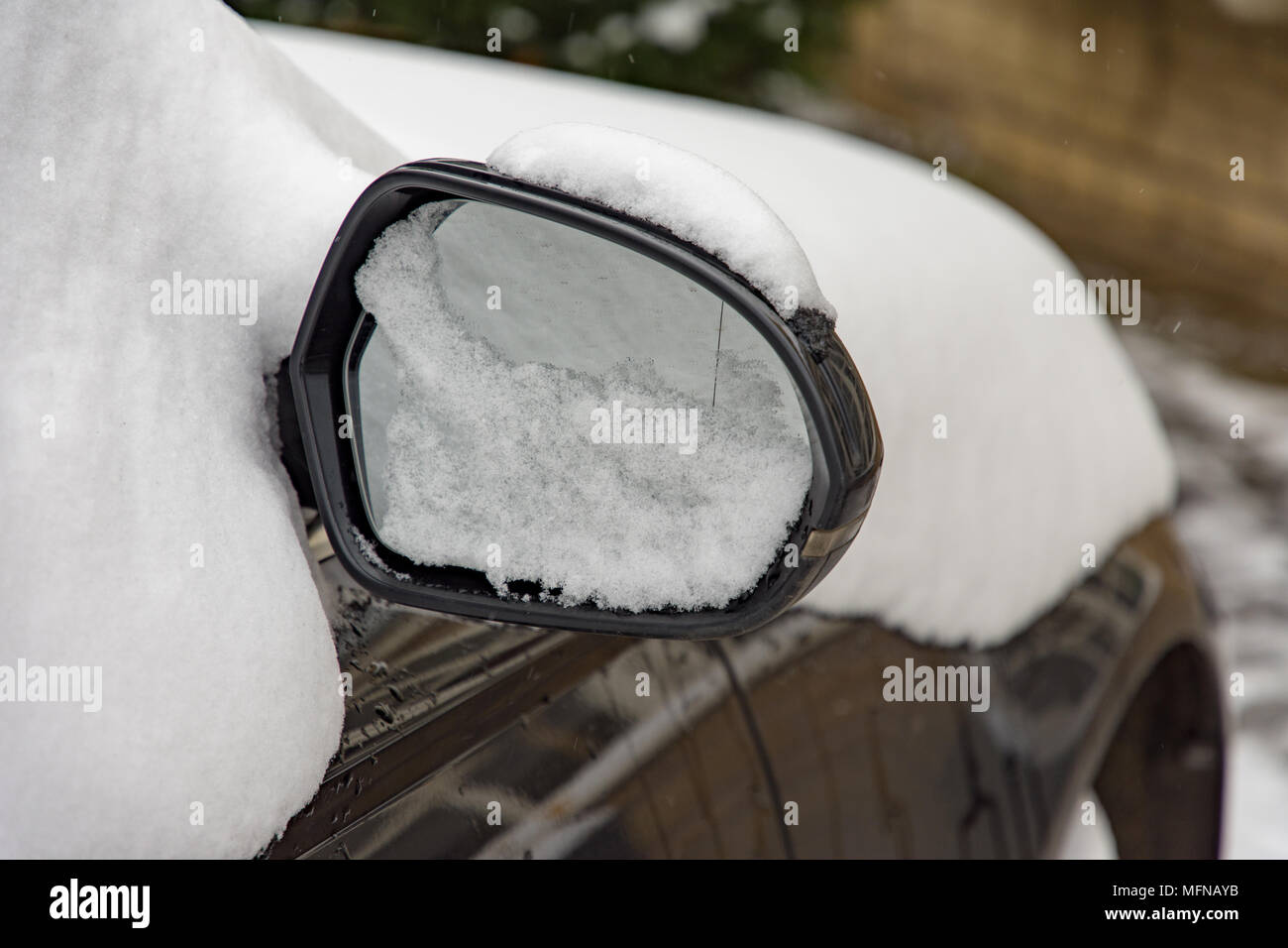 Snow on car ad mirror Stock Photo