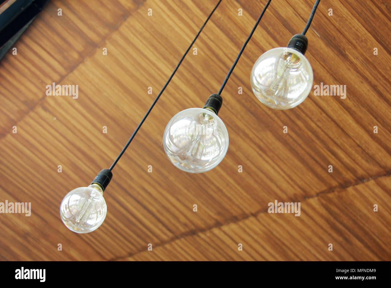 Three retro light bulbs hanging from wood ceiling in coffee shop Stock ...