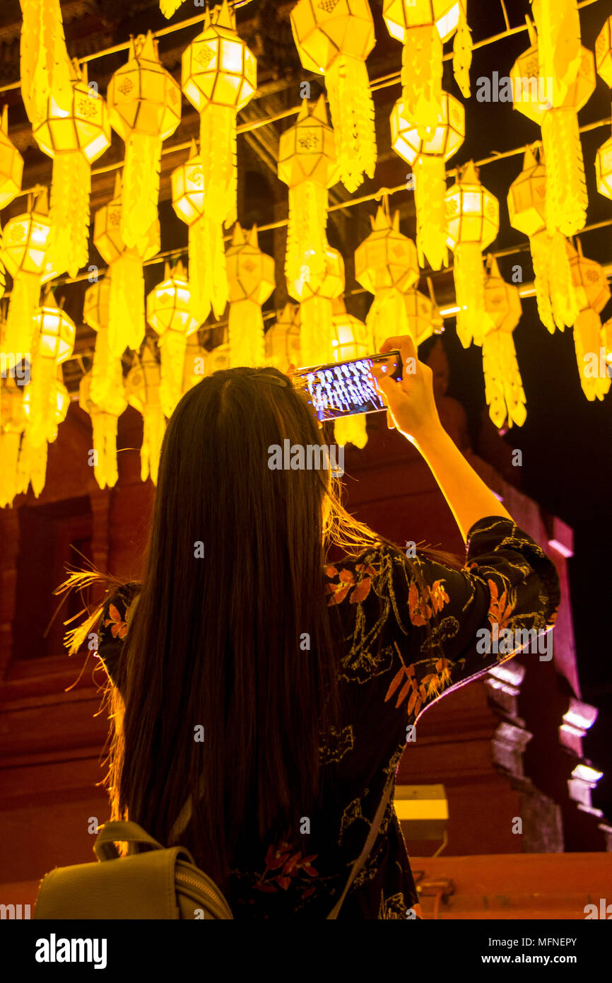 Female tourist taking picture of Northern Thai traditional lanterns with mobile smart phone Stock Photo